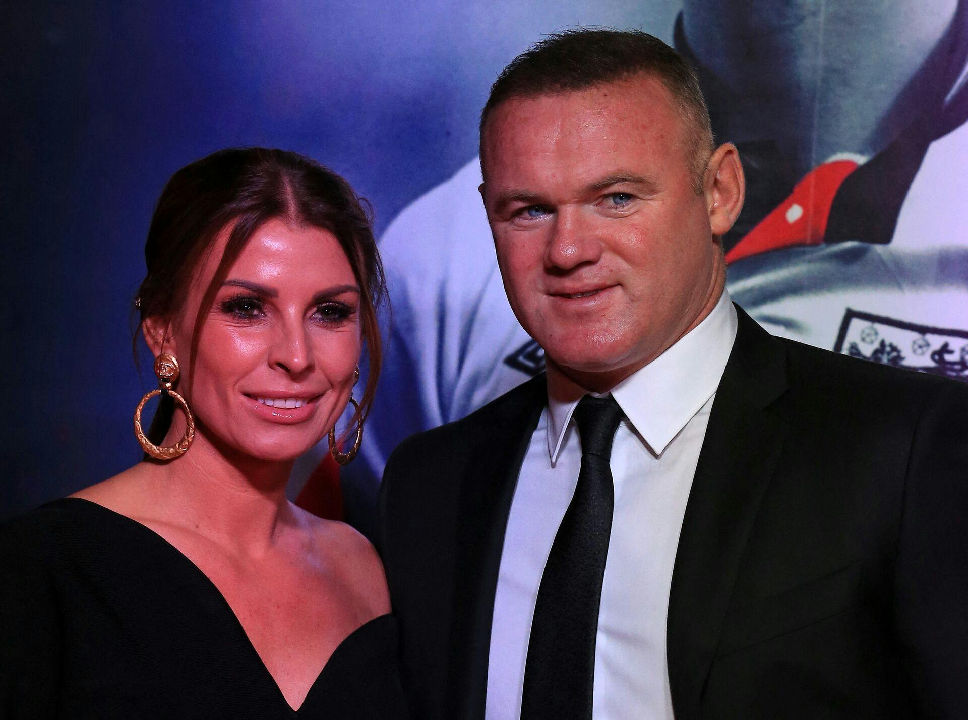 Former Manchester United and England footballer Wayne Rooney and his wife Coleen pose upon arrival to attend the World Premiere of ROBBO: The Bryan Robson Story, in Manchester, northern England on November 25, 2021. Lindsey Parnaby / AFP