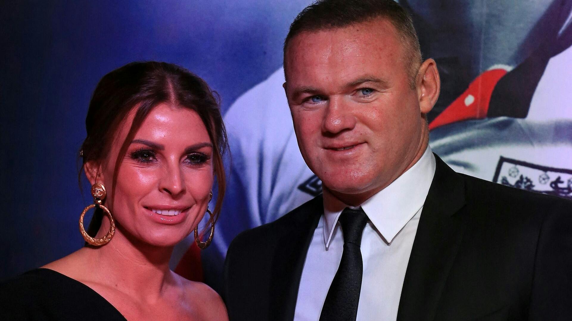 Former Manchester United and England footballer Wayne Rooney and his wife Coleen pose upon arrival to attend the World Premiere of ROBBO: The Bryan Robson Story, in Manchester, northern England on November 25, 2021. Lindsey Parnaby / AFP