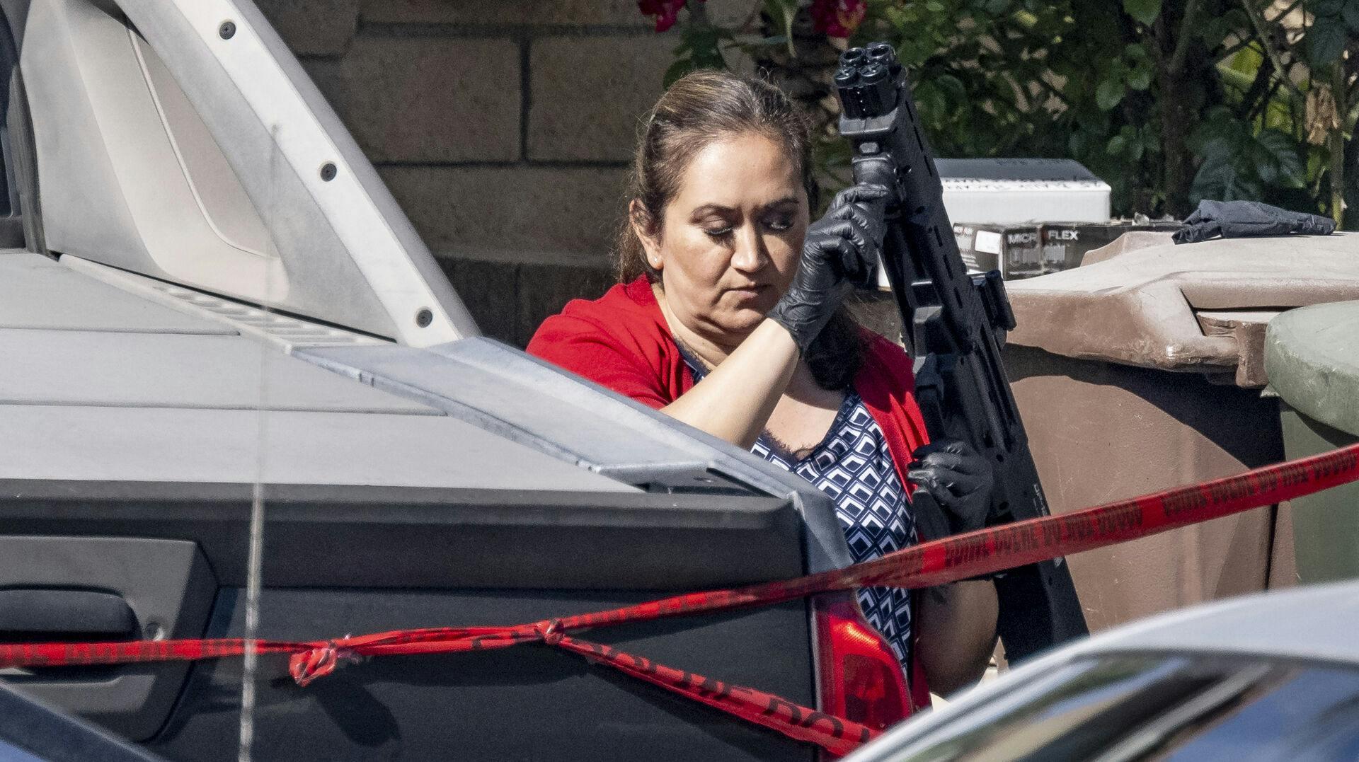 Den amerikanske dommer Jeffery Ferguson er blevet tiltalt for drabet på sin kone - her ses en betjent komme ud med et af de adskillige våben, der blev fundet hjemme hos den drabstiltalte dommer.