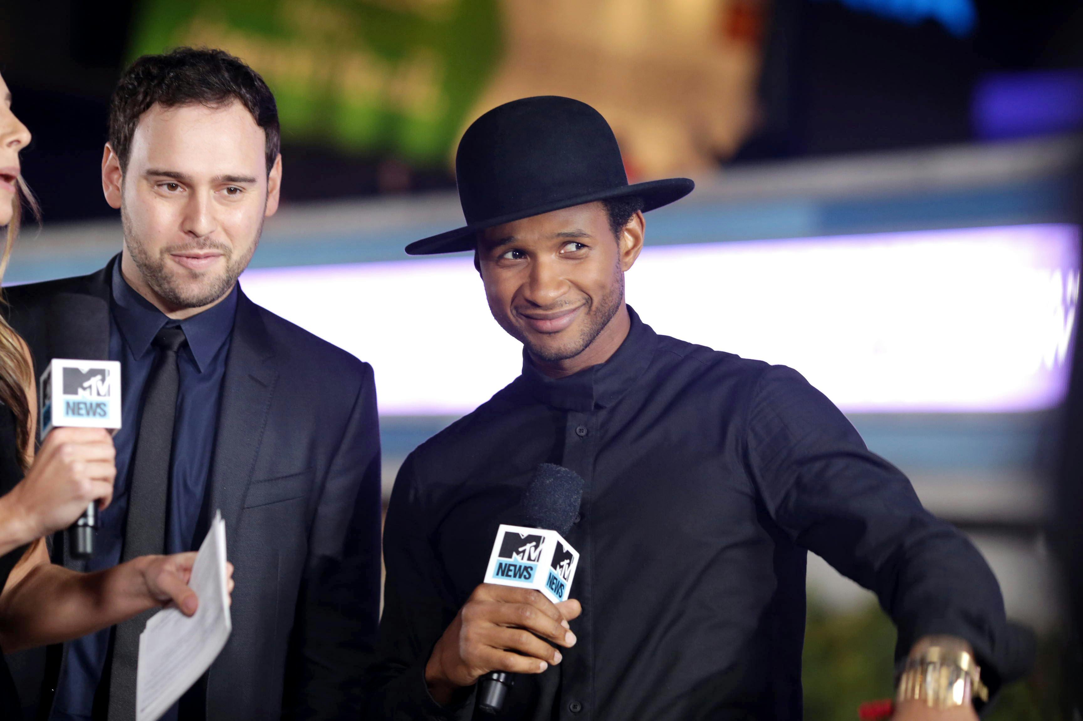 Producer Scooter Braun and Usher Raymond seen at the World Premiere of Open Road's "Justin Bieber's Believe" presented by Teen Vogue and sponsored by Clearasil, on Wednesday, Dec. 18, 2013 in Los Angeles. (Photo by Eric Charbonneau/Invision for Open Road Films/AP Images)