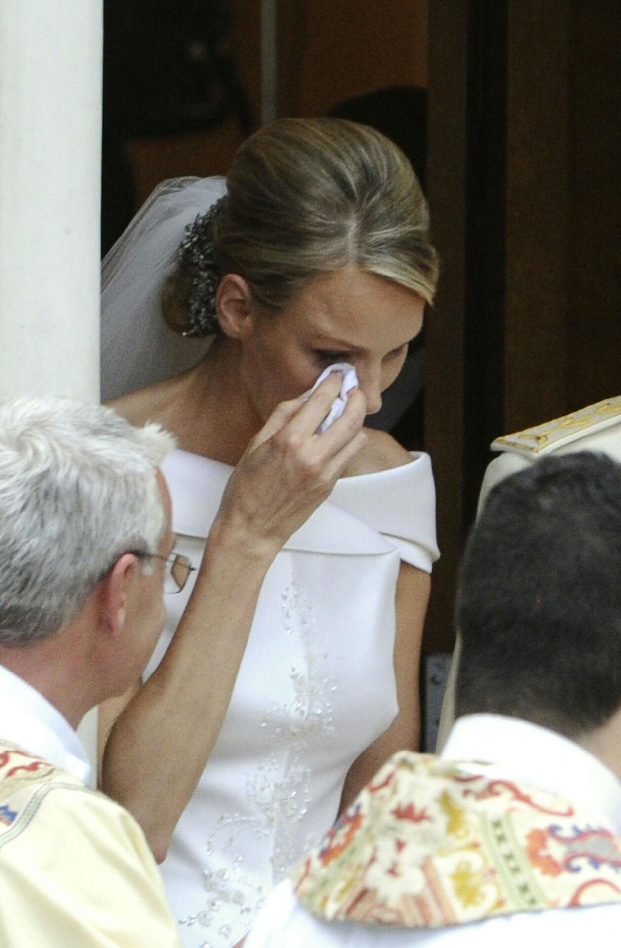 Princess Charlene of Monaco wipes a tear as she leaves with her husband Prince Albert II of Monaco after laying the bride's bouquet at the Sainte Devote's Church following their religious wedding on July 2, 2011 in Monaco. AFP PHOTO / MIGUEL MEDINA
