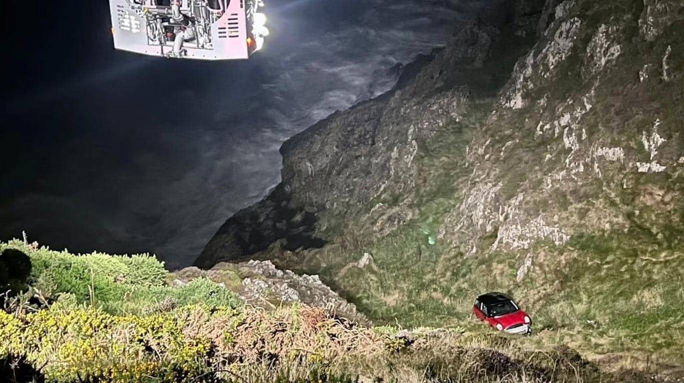 Den røde Mini Cooper var kommet på seriøse afveje - her ses to redningsfolk i aktion.