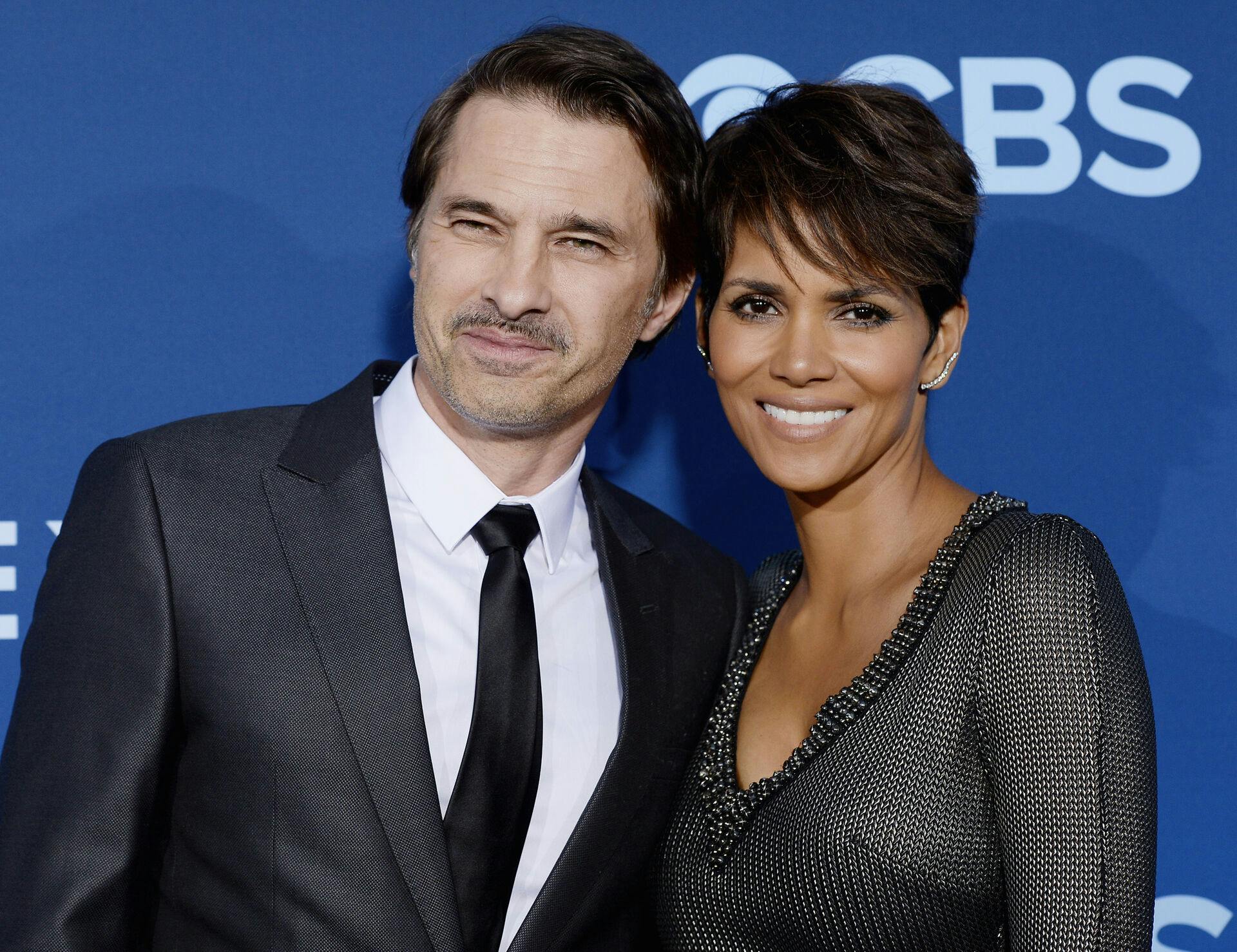 Halle Berry of the CBS science fiction television series "Extant, " poses with her husband Olivier Martinez during the premiere of the series in Los Angeles, California in this June 16, 2014 file photo. Martinez is under investigation for potential battery after he reportedly shoved a Los Angeles airport employee who may have been taking pictures of him. REUTERS/Kevork Djansezian/Files (UNITED STATES - Tags: ENTERTAINMENT)