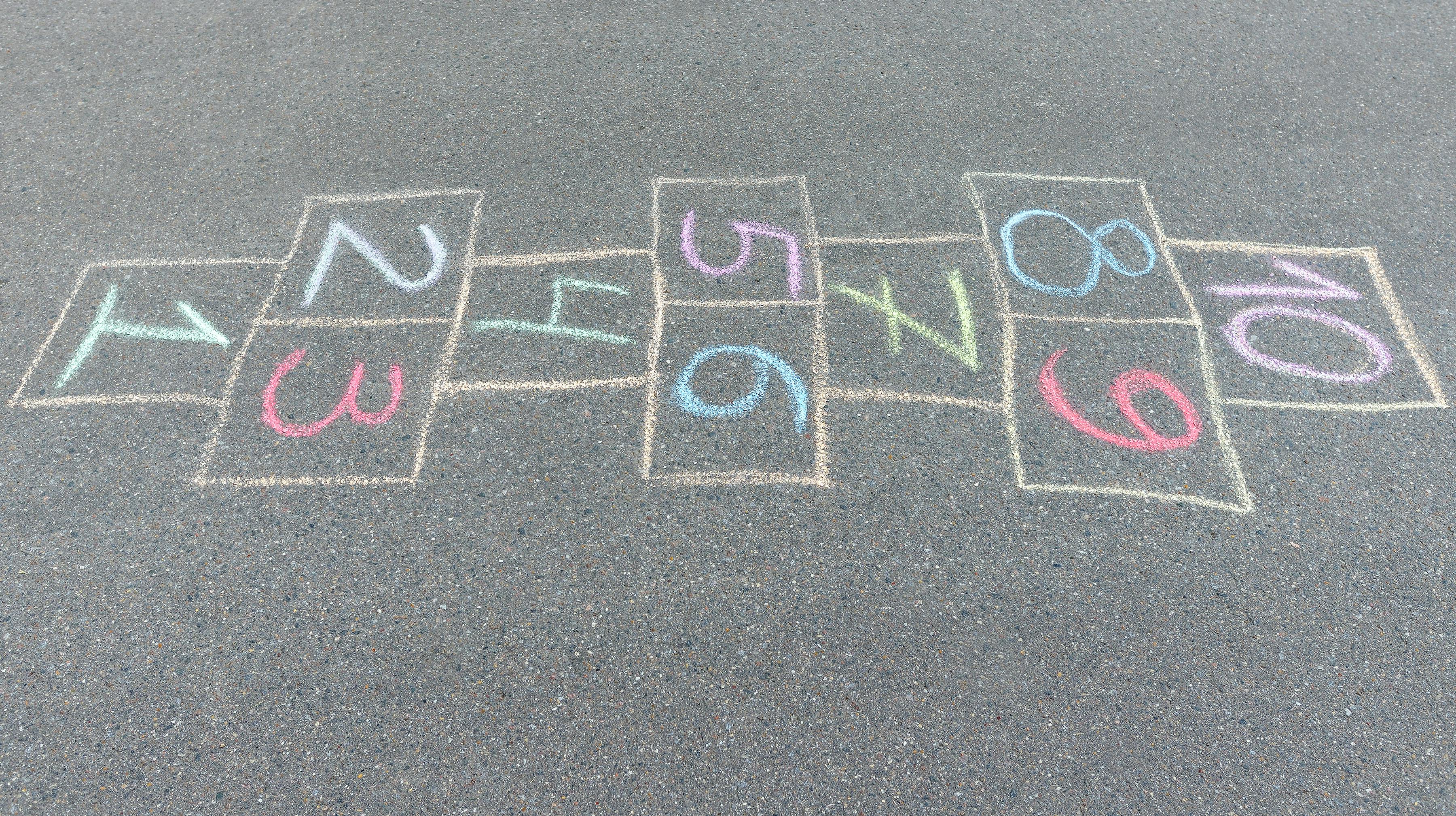 Close-up photo of chalk painted hopscotch on asphalt. School yard. Back to school. Outdoor activities for kids.