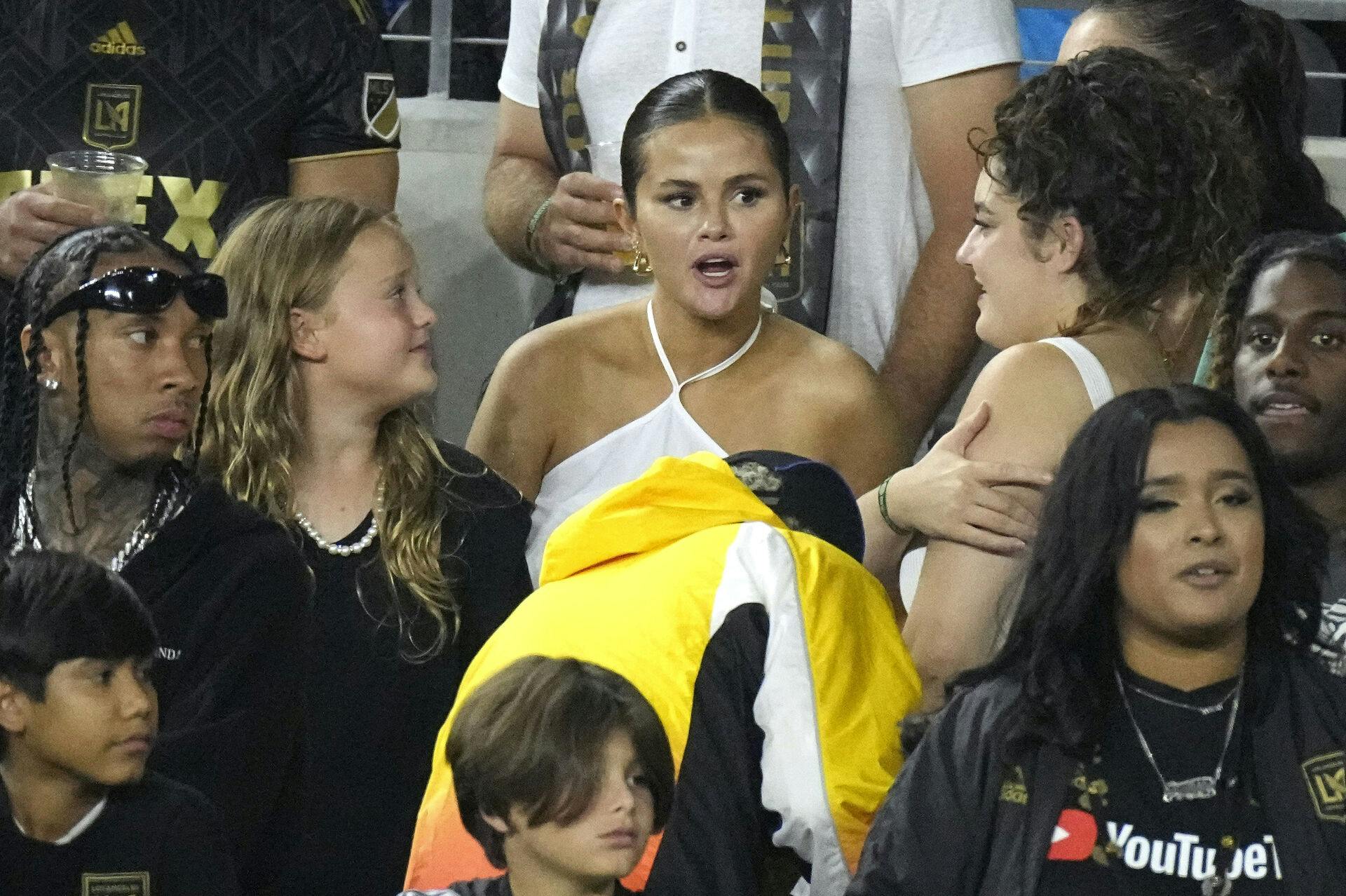 Selena Gomez blev spottet til fodboldkampen - rapperen Tyga ses også til venstre i billedet. 