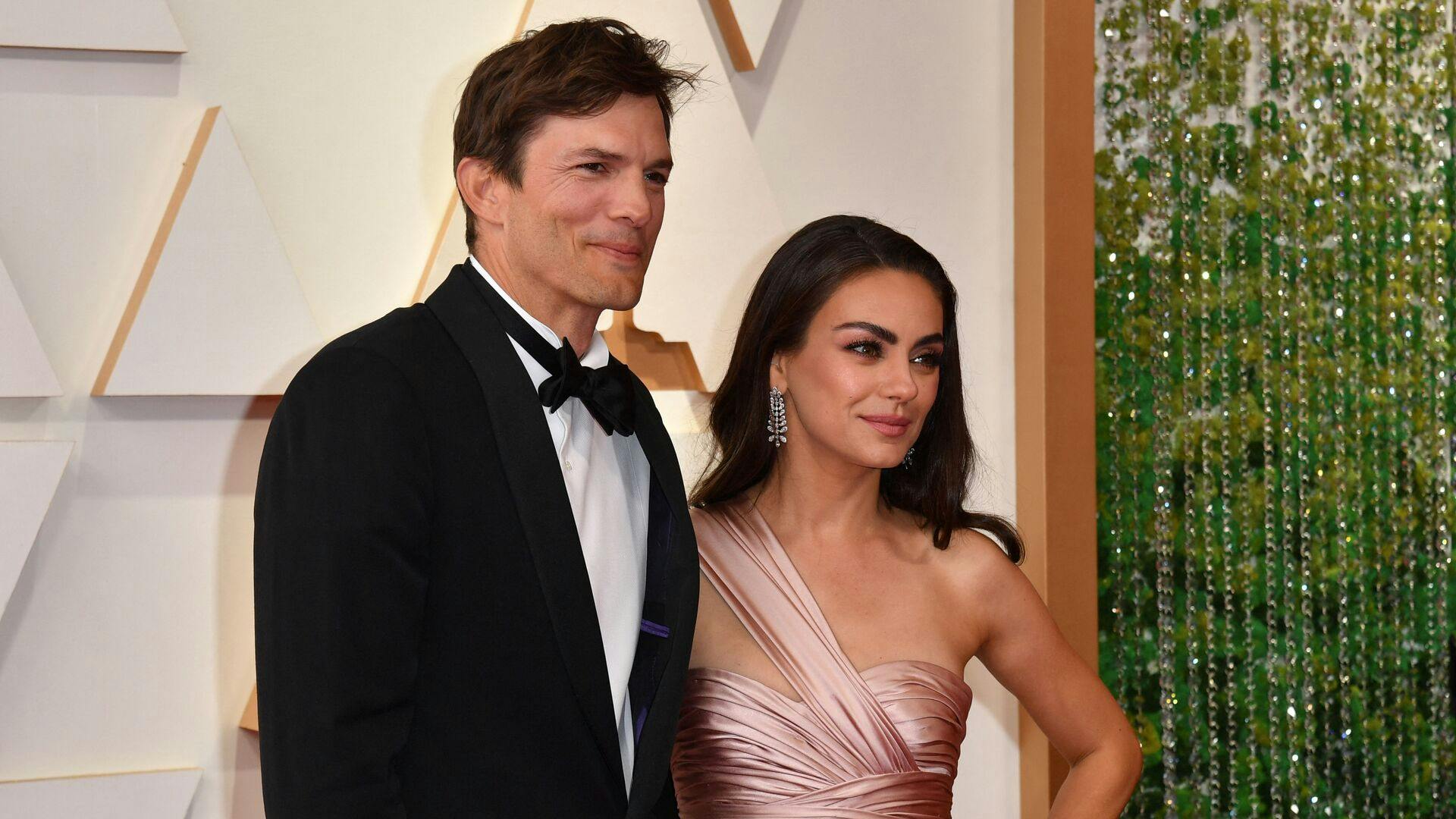 US actor Ashton Kutcher (L) and wife US actress Mila Kunis attend the 94th Oscars at the Dolby Theatre in Hollywood, California on March 27, 2022. (Photo by ANGELA WEISS / AFP)