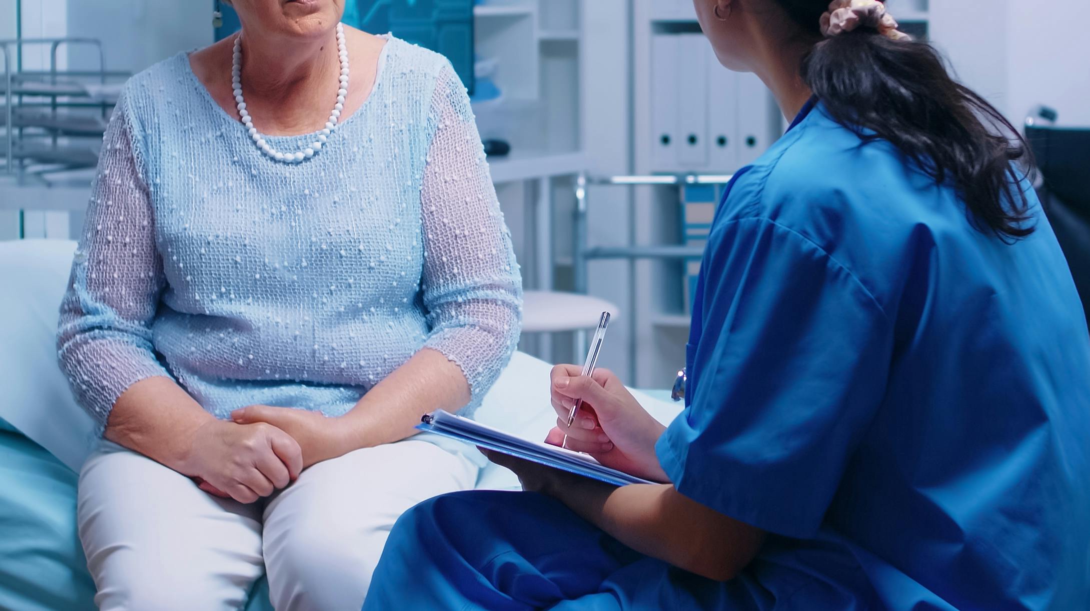 Old redired senior patient answering nurse questions before doctor appointment in modern private healthcare facility. Converstation with medical stuff hospital clinic medicine healthcare