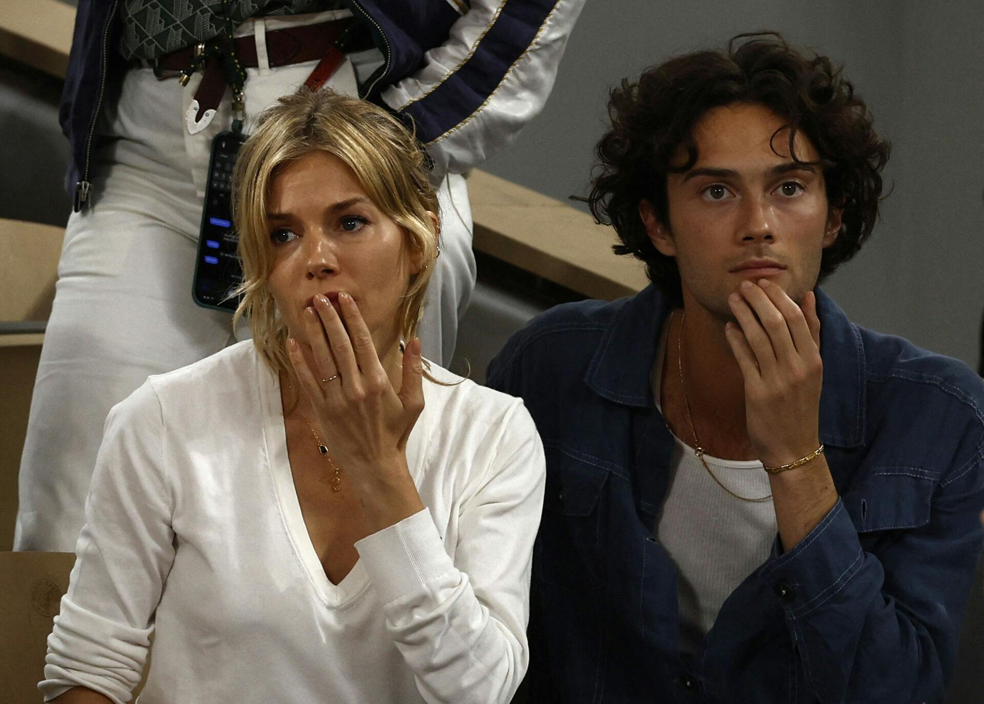 Tennis - French Open - Roland Garros, Paris, France - June 3, 2022 Sienna Miller and Oli Green react after Germany's Alexander Zverev retires from the match after sustaining an injury during the semi final match with Spain's Rafael Nadal REUTERS/Yves Herman