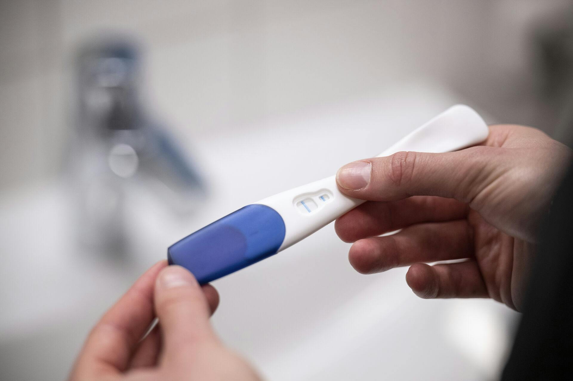 ILLUSTRATION - 12 April 2023, Berlin: A woman holds a positive pregnancy test in her hands. Photo by: Hannes P Albert/picture-alliance/dpa/AP Images