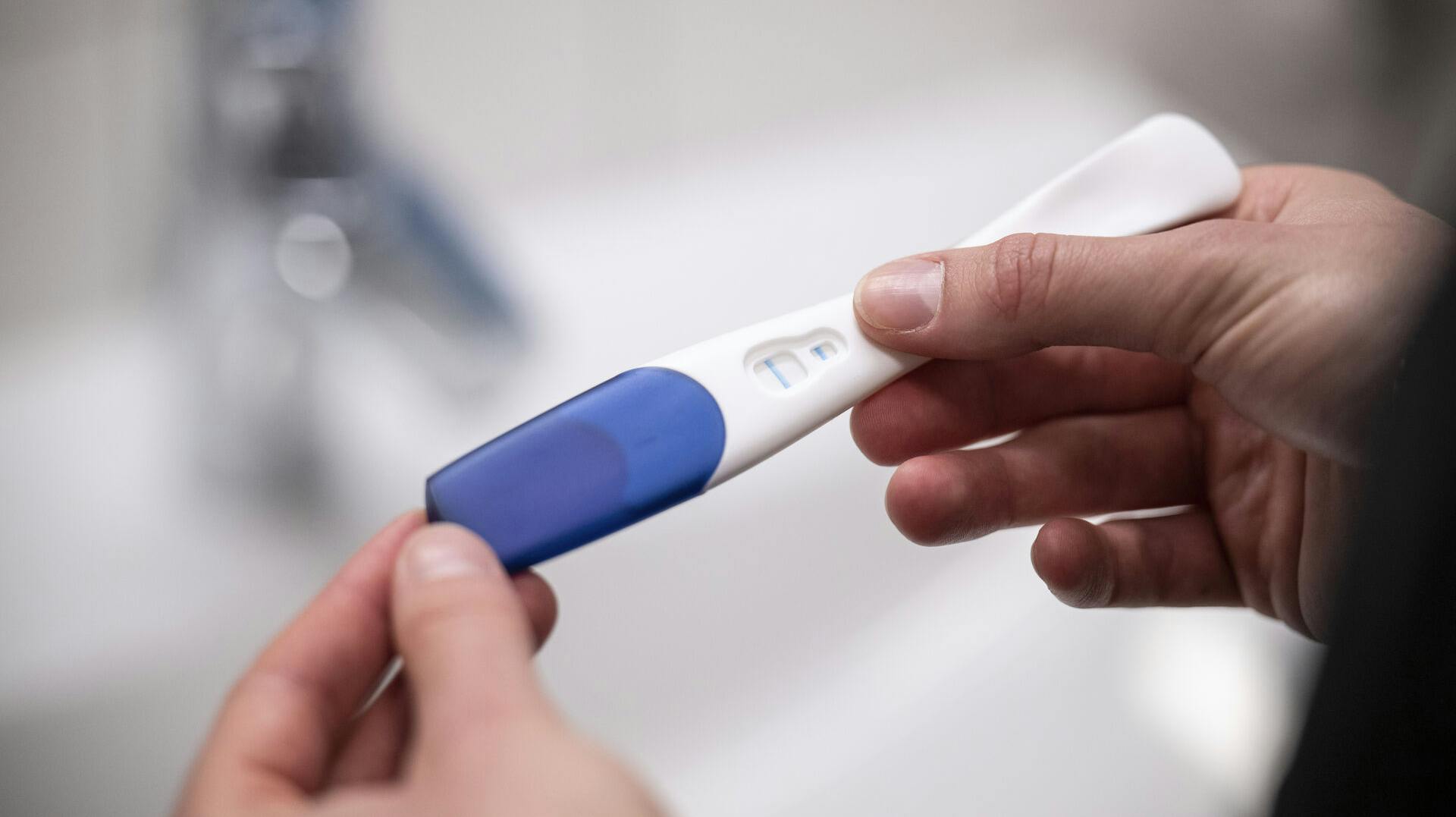 ILLUSTRATION - 12 April 2023, Berlin: A woman holds a positive pregnancy test in her hands. Photo by: Hannes P Albert/picture-alliance/dpa/AP Images