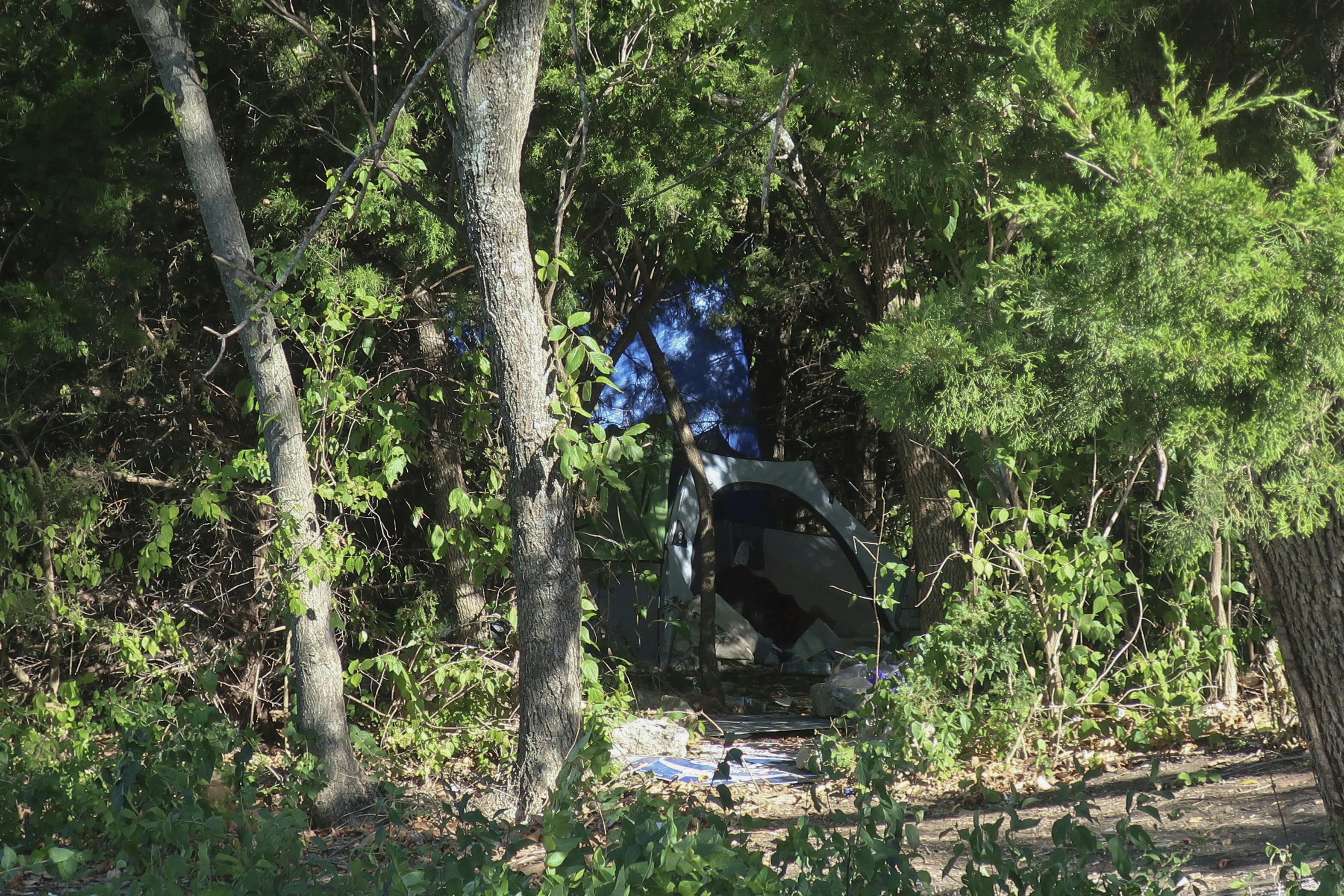 A tent sits in a grove of trees on a wooded lot amid businesses in Topeka, Kan., Thursday, Oct. 5, 2023. Neighbors suspect Zoey Felix, 5, Mickel Cherry and Zoey's father were living there, although police haven't confirmed that. Cherry, a homeless man, has been charged with the murder and rape of Felix and could face the death penalty in connection with the girl's death on Monday, Oct. 2. (AP Photo/John Hanna)