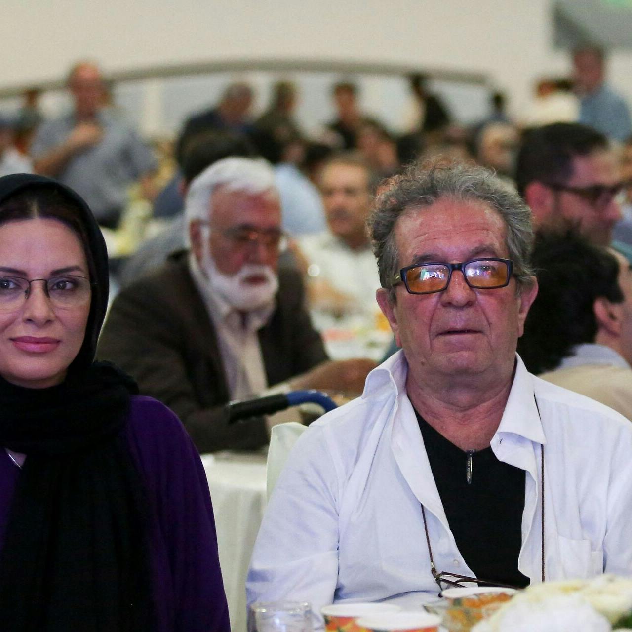 (FILES) Iranian film director Dariush Mehrjui and his wife Vahida Mohammadifar attend a ceremony in Tehran on July 1, 2015. One of Iran's most important film-makers, Mehrjui, was stabbed to death on October 14 alongside his wife at their home near the Iranian capital. The 83-year-old was indelibly associated with the Iranian new wave of cinema, having made "The Cow" in 1969, one of the movement's first films. (Photo by Abdulwahed MIRZAZADEH / isna news / AFP)