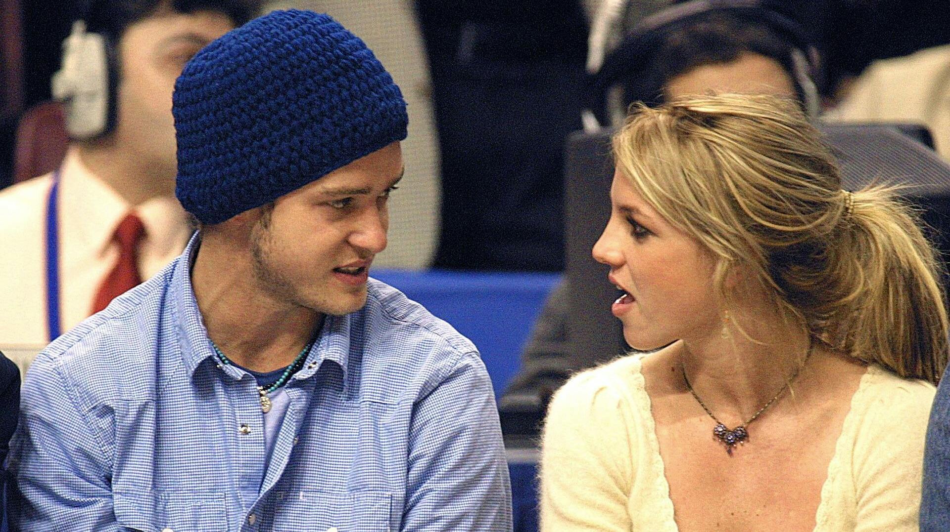 Pop superstars Britney Spears (R) and boyfriend Justin Timberlake (L) talk as they sit courtside at the NBA All-Star Game 10 February 2002 in Philadelphia. AFP Photo / Tom Mihalek