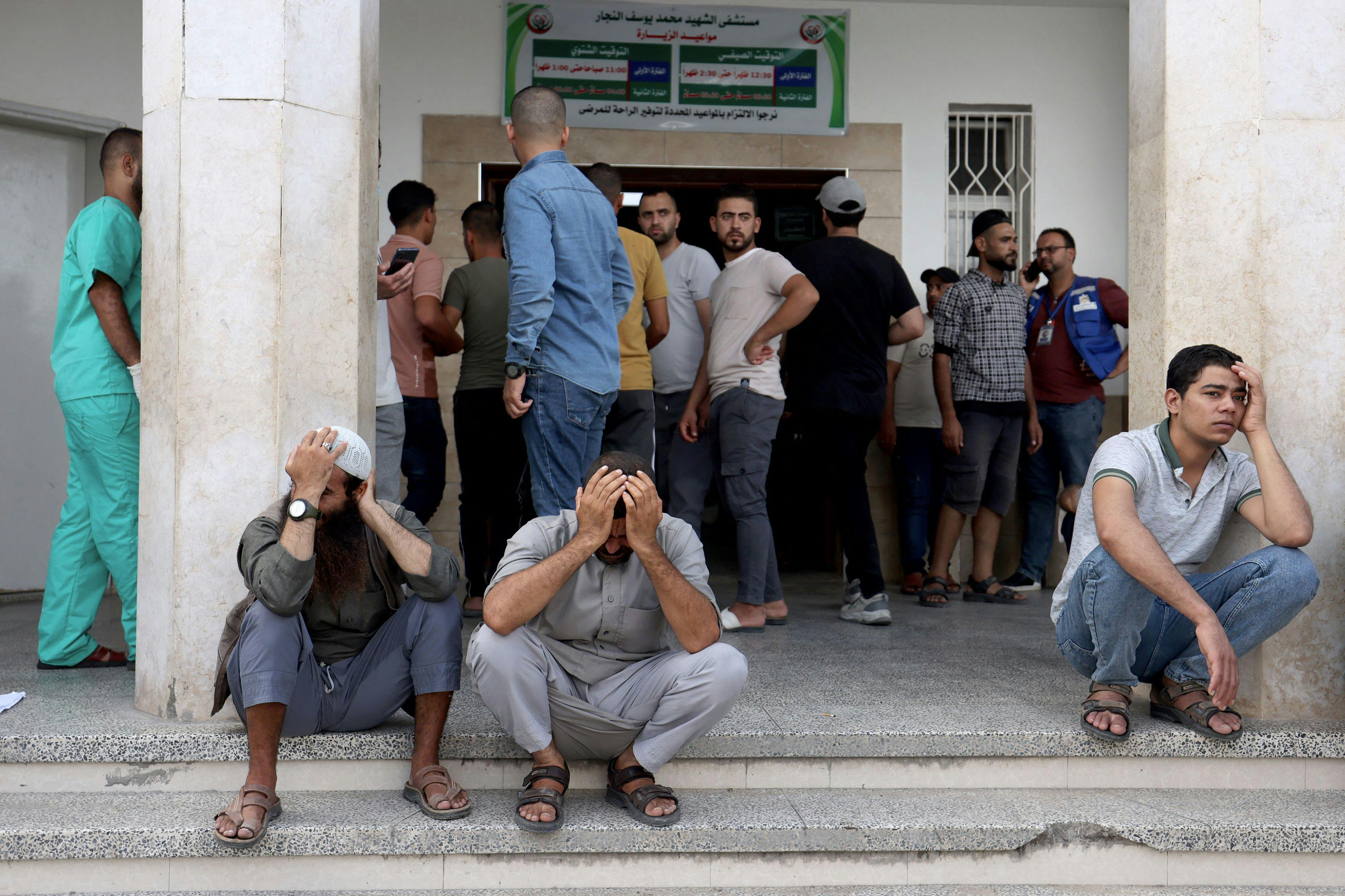 Palæstinensiske mænd sidder tynget af sorg ude foran et hospital i det sydlige Gaza den 17. oktober. Her har et israelsk luftangreb ramt hospitalet i Rafah. 