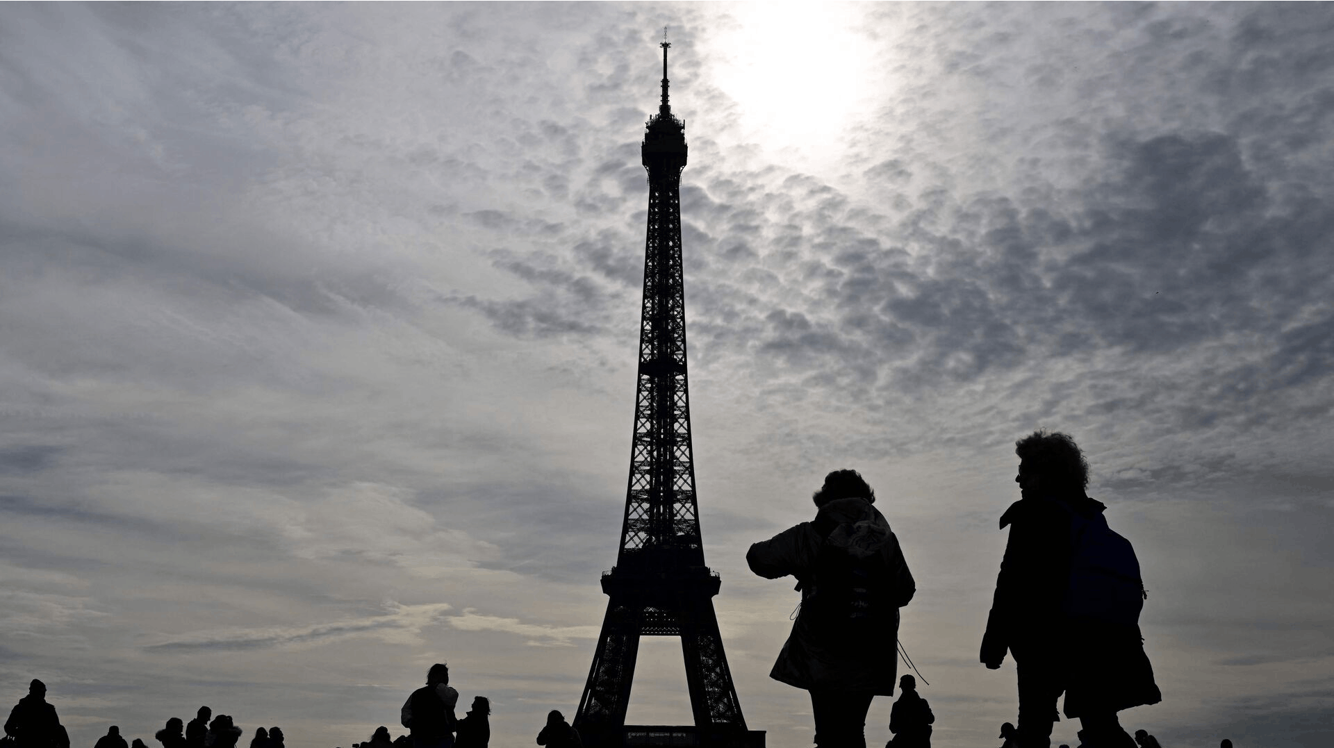 Tourists walk on the Trocadero square with the Eiffel tower in the background on october 18, 2023. (Photo by MIGUEL MEDINA / AFP)