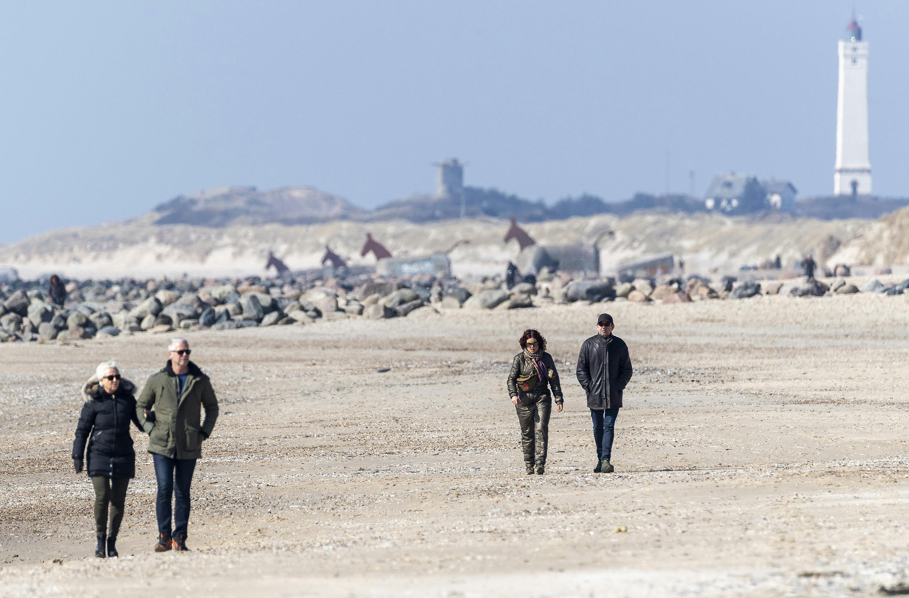 Folk nyder solen på Hvidbjerg Strand ved Blåvand mens Corona krisen raser. Den 27. marts 2020.. (Foto: John Randeris/Ritzau Scanpix)