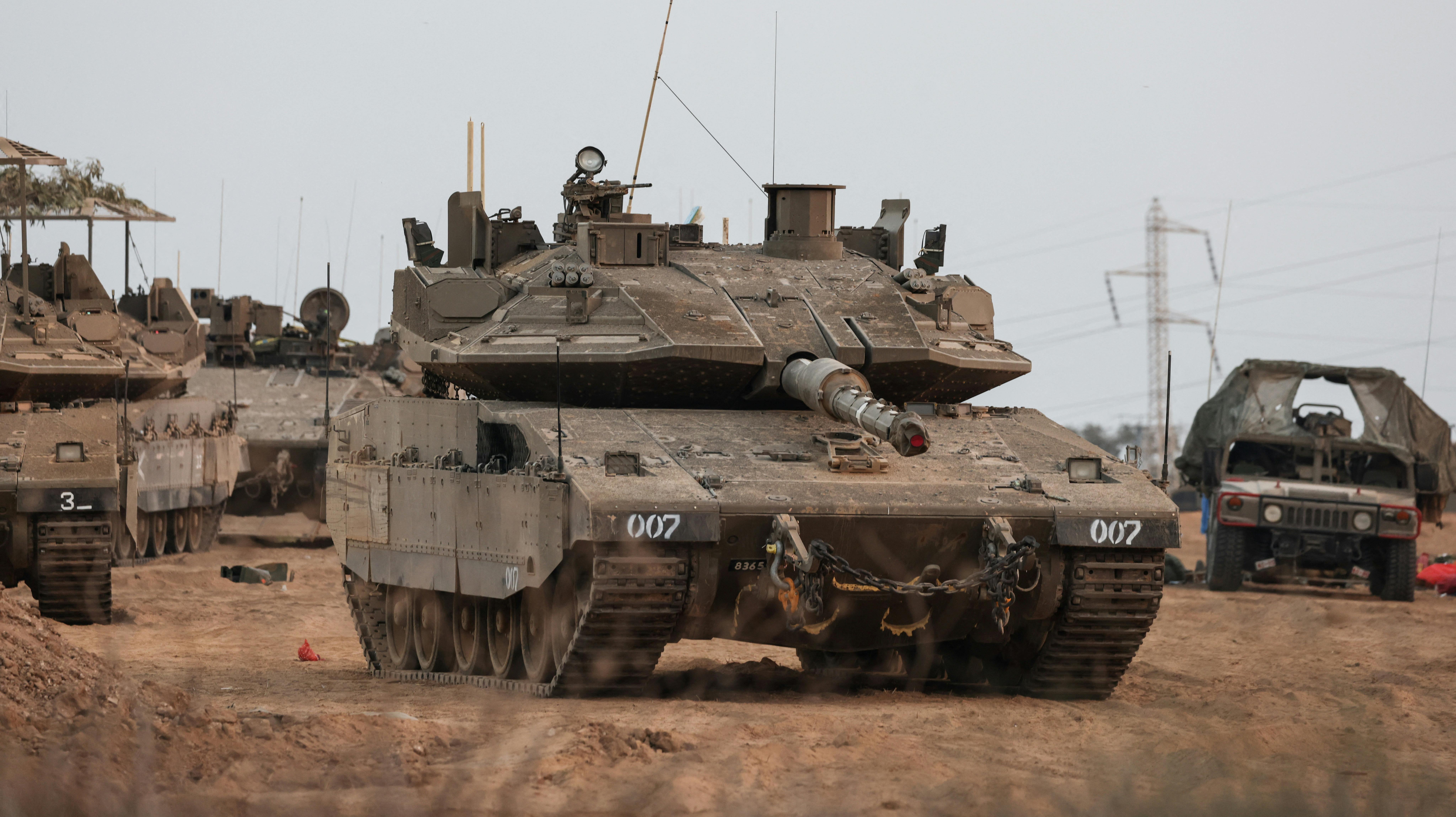 An Israeli tank and military vehicles are seen near Israel's border with the Gaza Strip, in southern Israel, October 22, 2023. REUTERS/Violeta Santos Moura