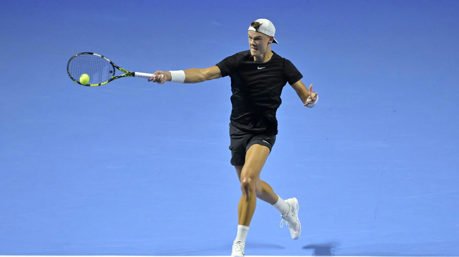 epaselect epa10936504 Denmark's Holger Rune returns a ball to Serbia's Miomir Kecmanovic during their first round match at the Swiss Indoors tennis tournament at the St. Jakobshalle in Basel, Switzerland, 24 October 2023. EPA/GEORGIOS KEFALAS