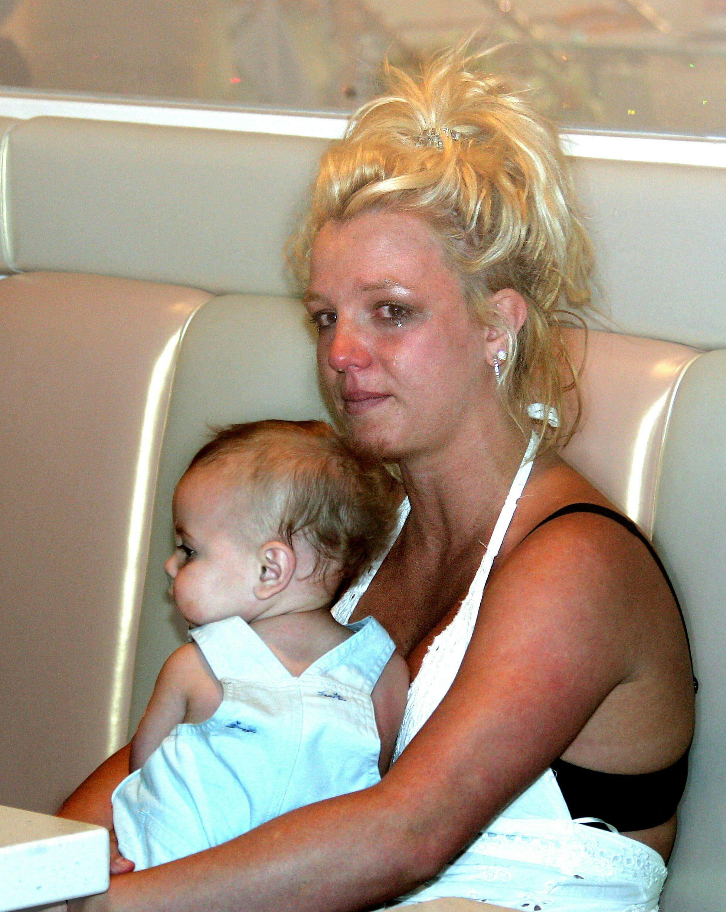 En trist Britney Spears i 2006 umiddelbart efter hun var ved at falde på gaden med sin lille søn i armene.