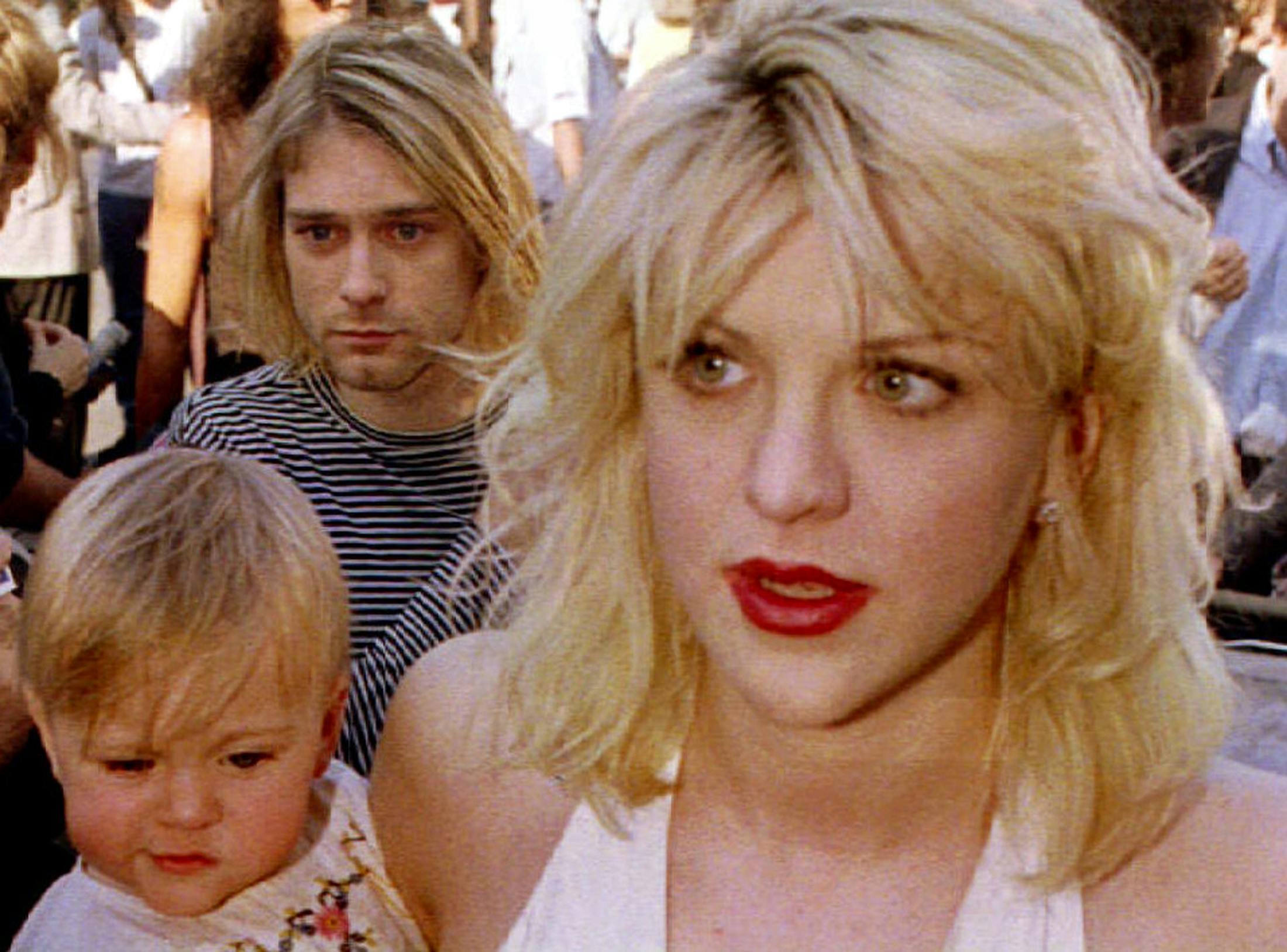Frances Bean Cobain er det eneste barn af Kurt Cobain. Her ses hun i favnen på sin mor Courtney Love i 1992, mens farmand ses lige bagved. 