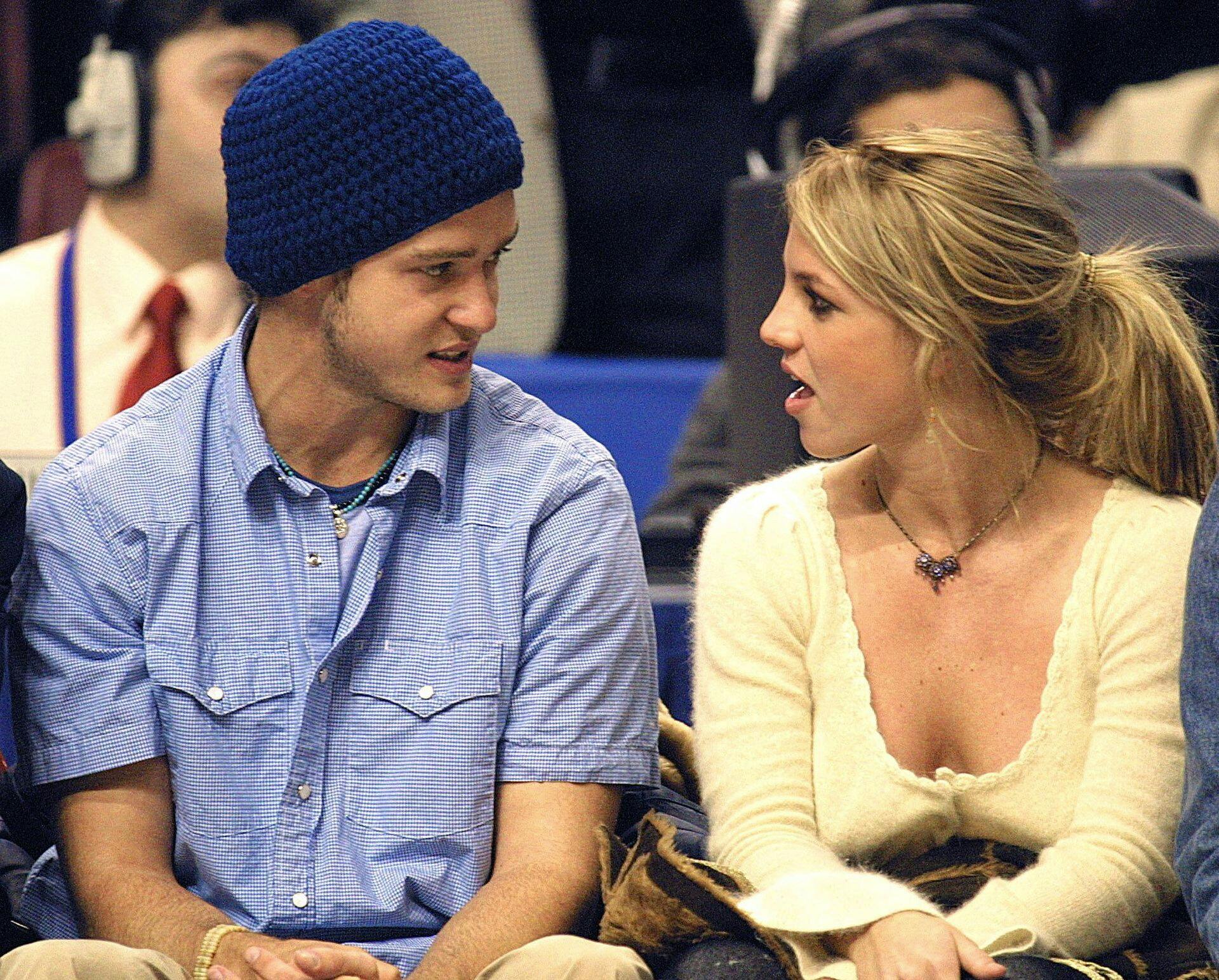 (FILES) Pop superstars Britney Spears (R) and boyfriend Justin Timberlake (L) talk as they sit courtside at the NBA All-Star Game 10 February 2002 in Philadelphia. Britney Spears says in her eagerly anticipated new memoir that she had an abortion during her relationship with Justin Timberlake over two decades ago, according to an excerpt released October 17, 2023. (Photo by TOM MIHALEK / AFP)