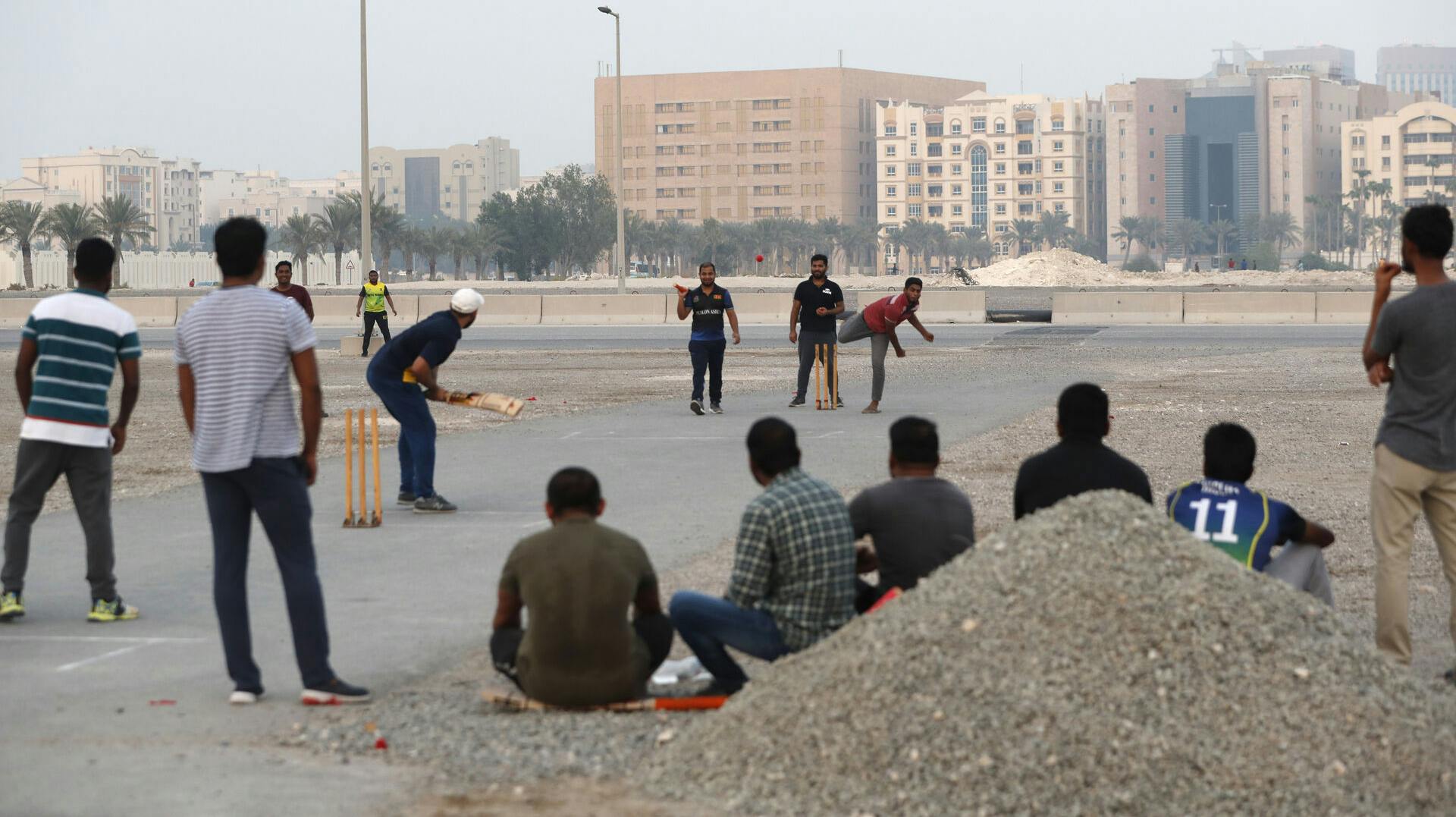 Migrantarbejdere spiller cricket i Doha, Qatars hovedstad. Blandt de mange migrantarbejdere i landet er titusinder af indere.