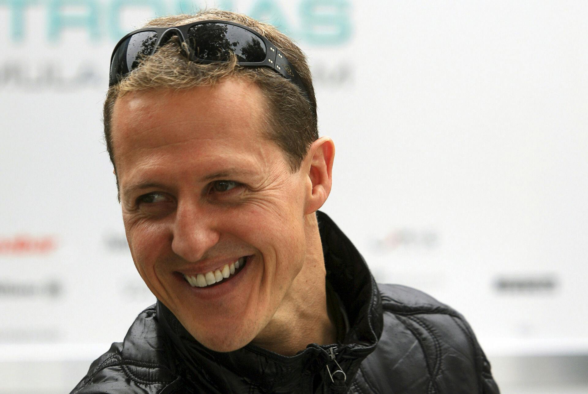 Mercedes Formula One driver Michael Schumacher of Germany smiles at the back of the pits ahead of this weekend's Australian Grand Prix in Melbourne in this March 24, 2011 file photo. Formula One ex-champion Schumacher, who sustained severe head injuries in a ski accident in late 2013, is no longer in a coma and has left the French hospital where he was being treated since the accident, his spokeswoman said on June 16, 2014. REUTERS/Scott Wensley/Files (AUSTRALIA - Tags: SPORT MOTORSPORT F1)