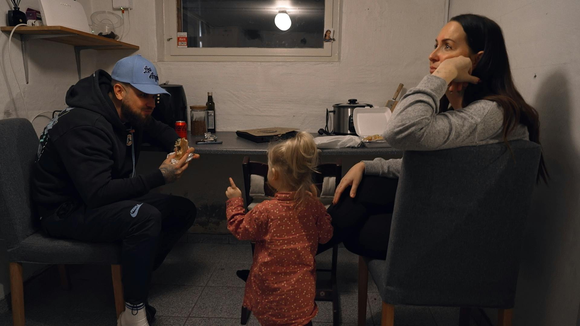 Her nyder familien lidt takeaway i kælderen, da deres hus ikke har et køkken.