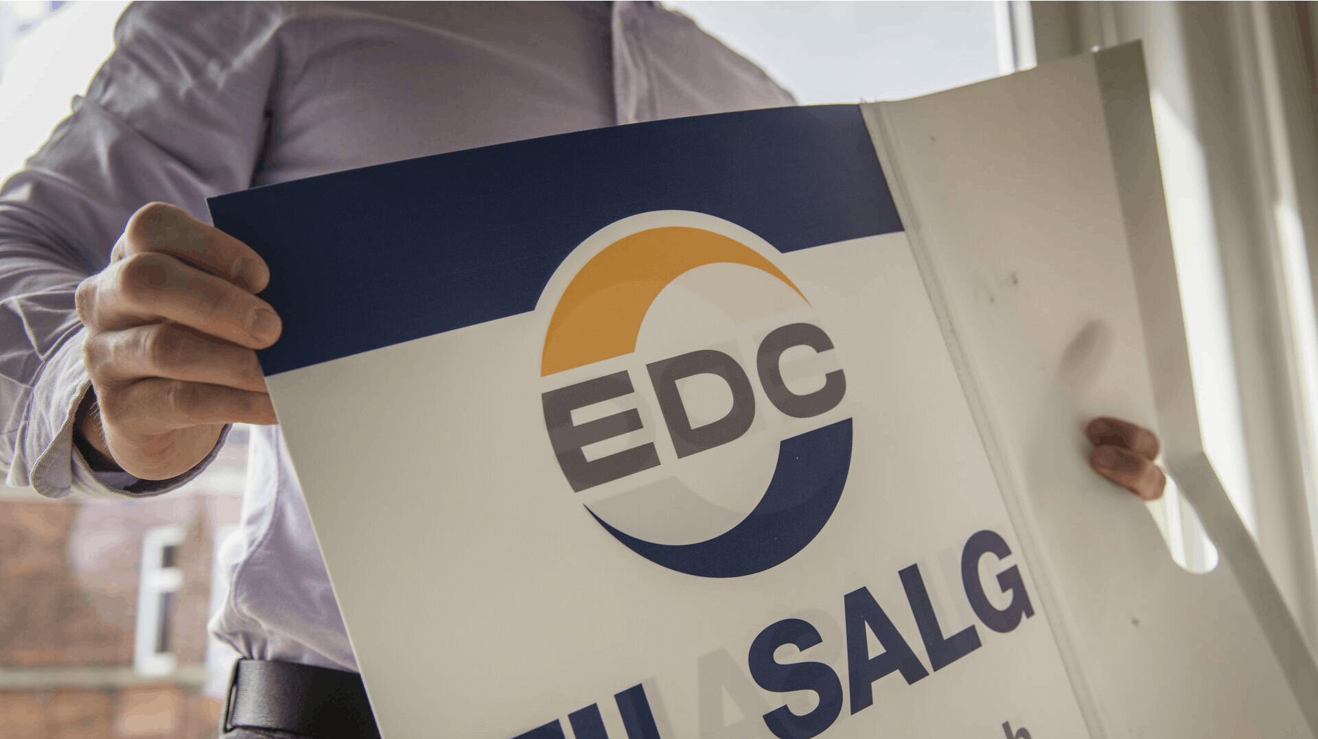 Lejlighed til salg på Bianco Lunos Allé på Frederiksberg. En ejendomsmægler fra EDC hænger et skilt op i lejlighedens vindue.