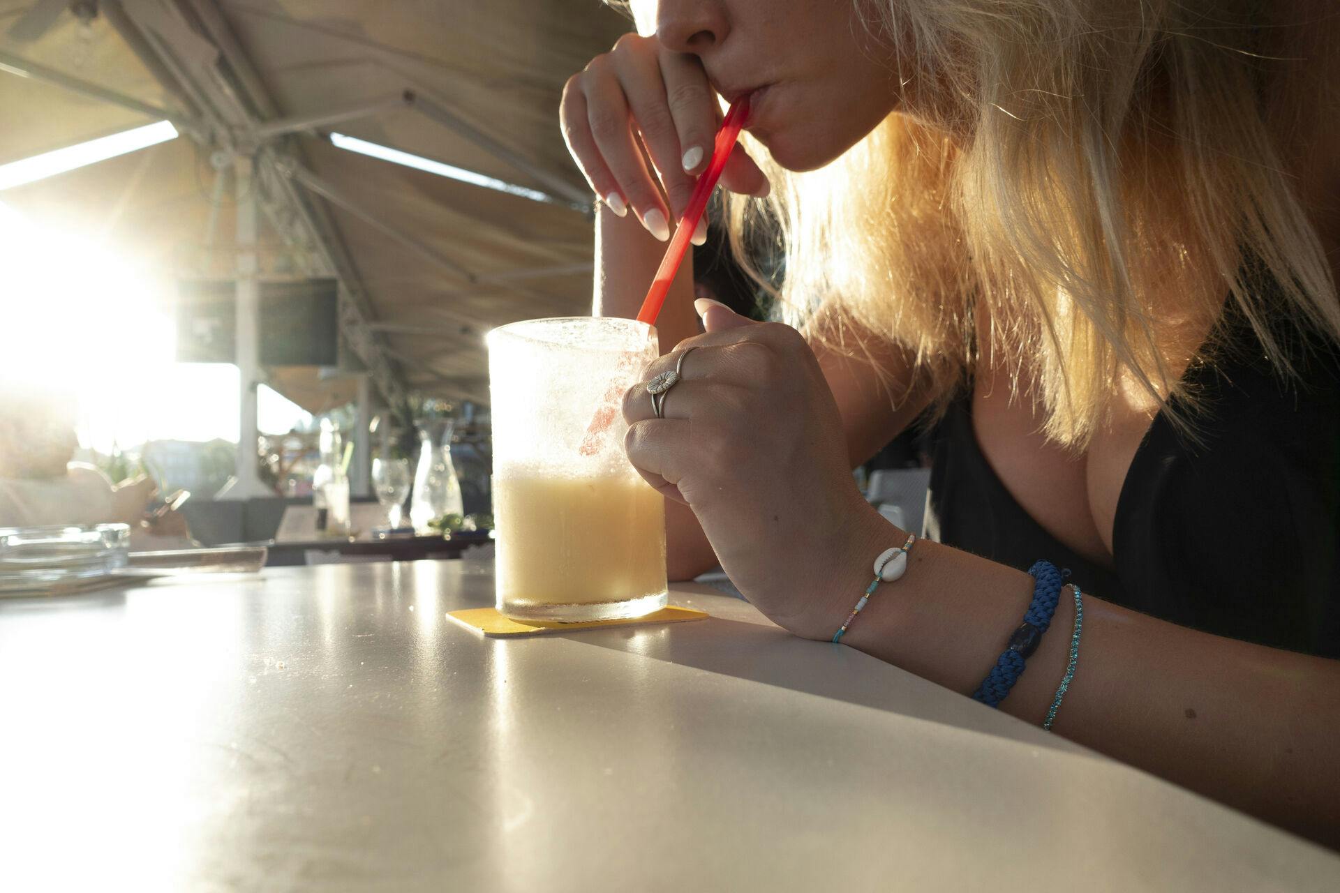 Ung kvinde og teenagepige med Pina Colada drinks ved strand og strandcafe og bar ved kyst og strand i Split i Kroatien. Split er en af de vigtigste kroatiske havnebyer ved Adriaterhavet.