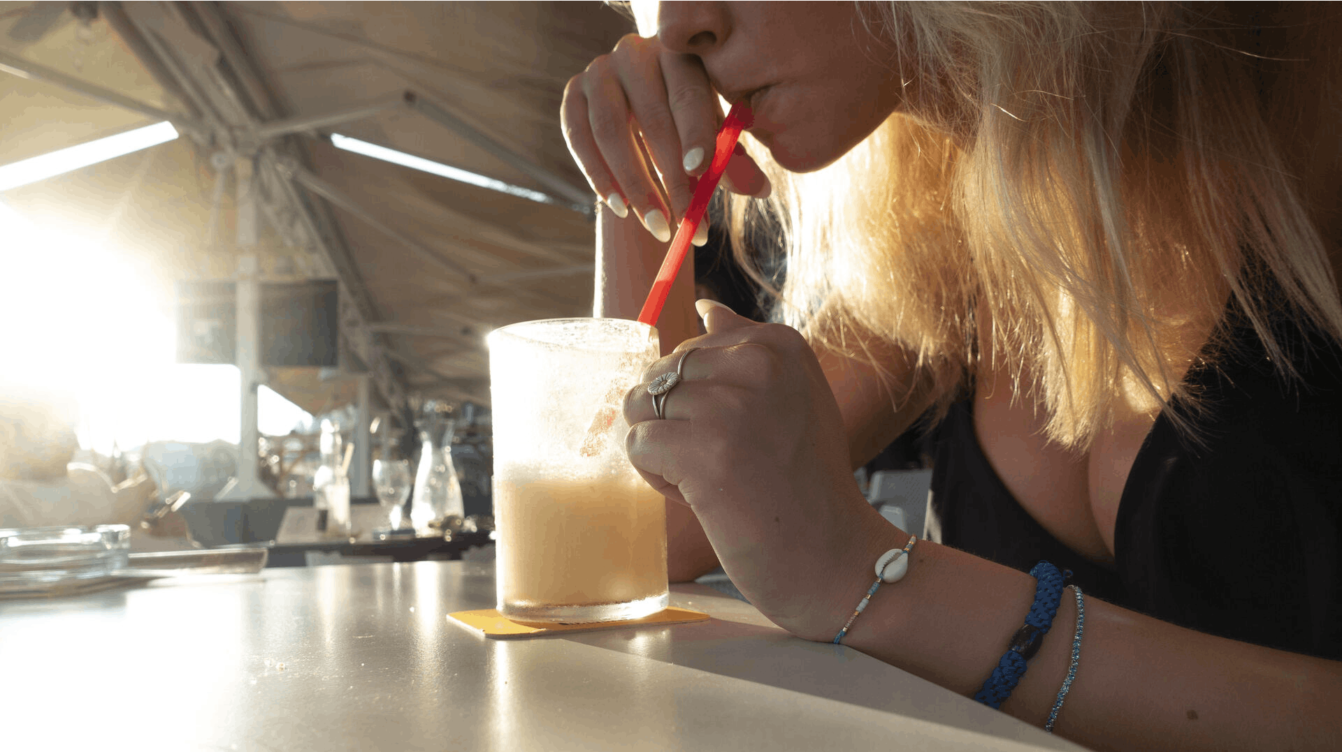 Ung kvinde og teenagepige med Pina Colada drinks ved strand og strandcafe og bar ved kyst og strand i Split i Kroatien. Split er en af de vigtigste kroatiske havnebyer ved Adriaterhavet.