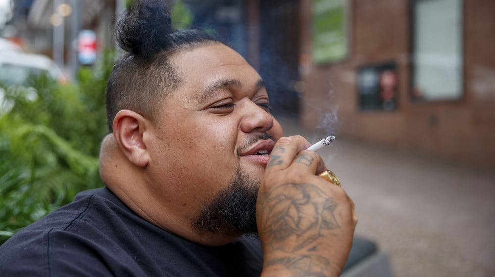 En mand nyder en cigaret på gaden i Auckland. (Arkivfoto).