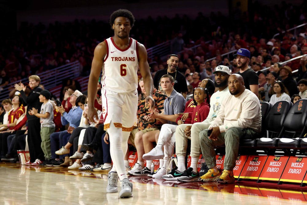 LeBron James (iført hvid kasket, red.) ser sin søns debut i collegebasketball søndag.