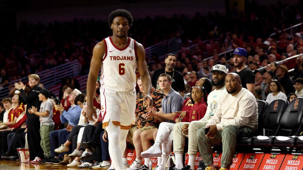 LeBron James (iført hvid kasket, red.) ser sin søns debut i collegebasketball søndag.