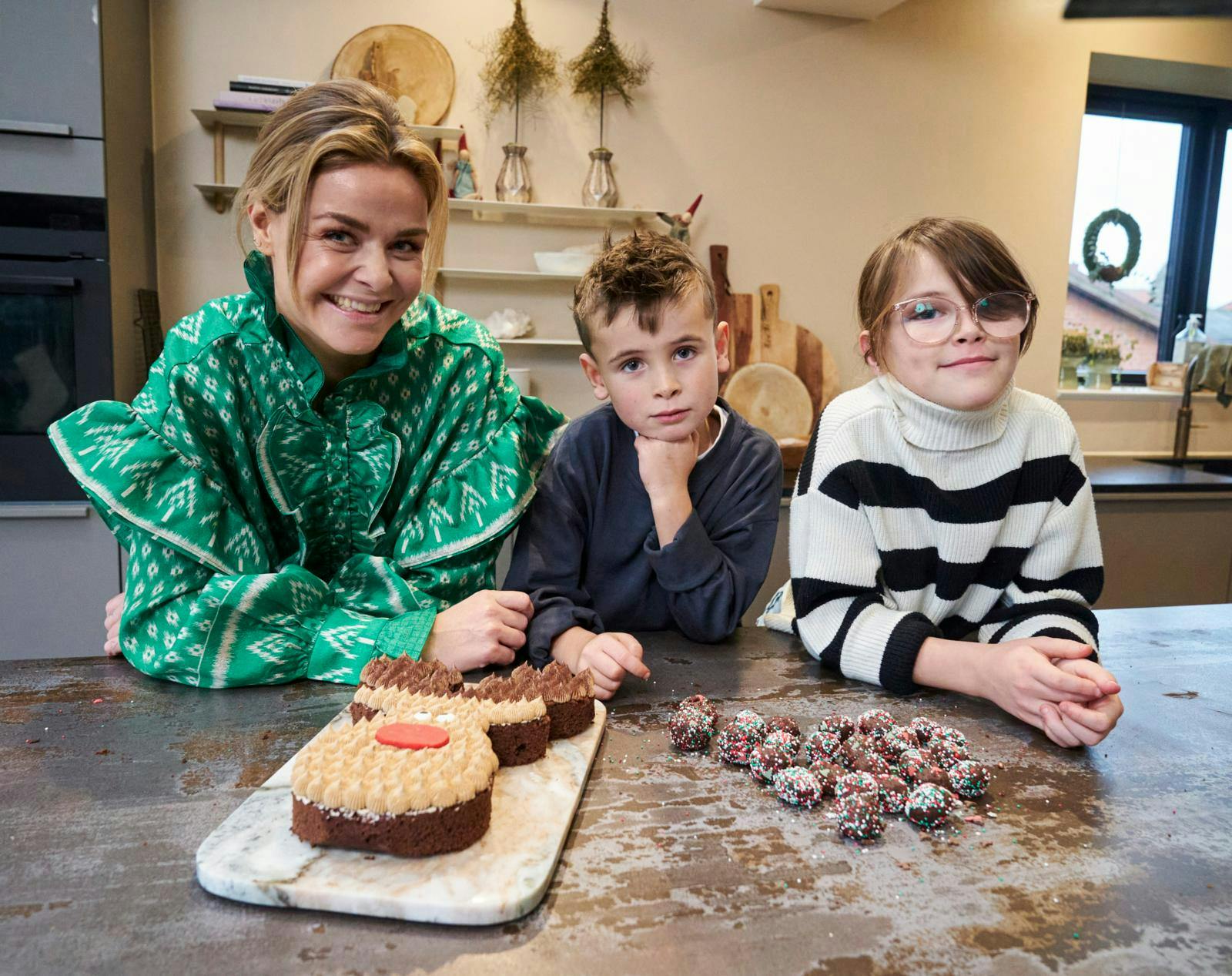 Ditte Julie Jensen, 36, nyder at være i køkkenet med sine børn, Albert på syv og Karla på 10 år. Her har de bagt en Rudolf-kage af chokoladekage og brugt resterne til romkugler.