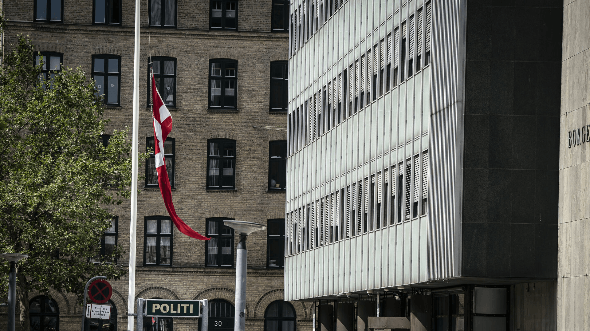 Flagstangen forsvinder snart helt sammen med politistationen på Halmtorvet i København. Her flages der på halv, efter betjent mistede livet i tjeneste i trafikuheld på Langebro i København.