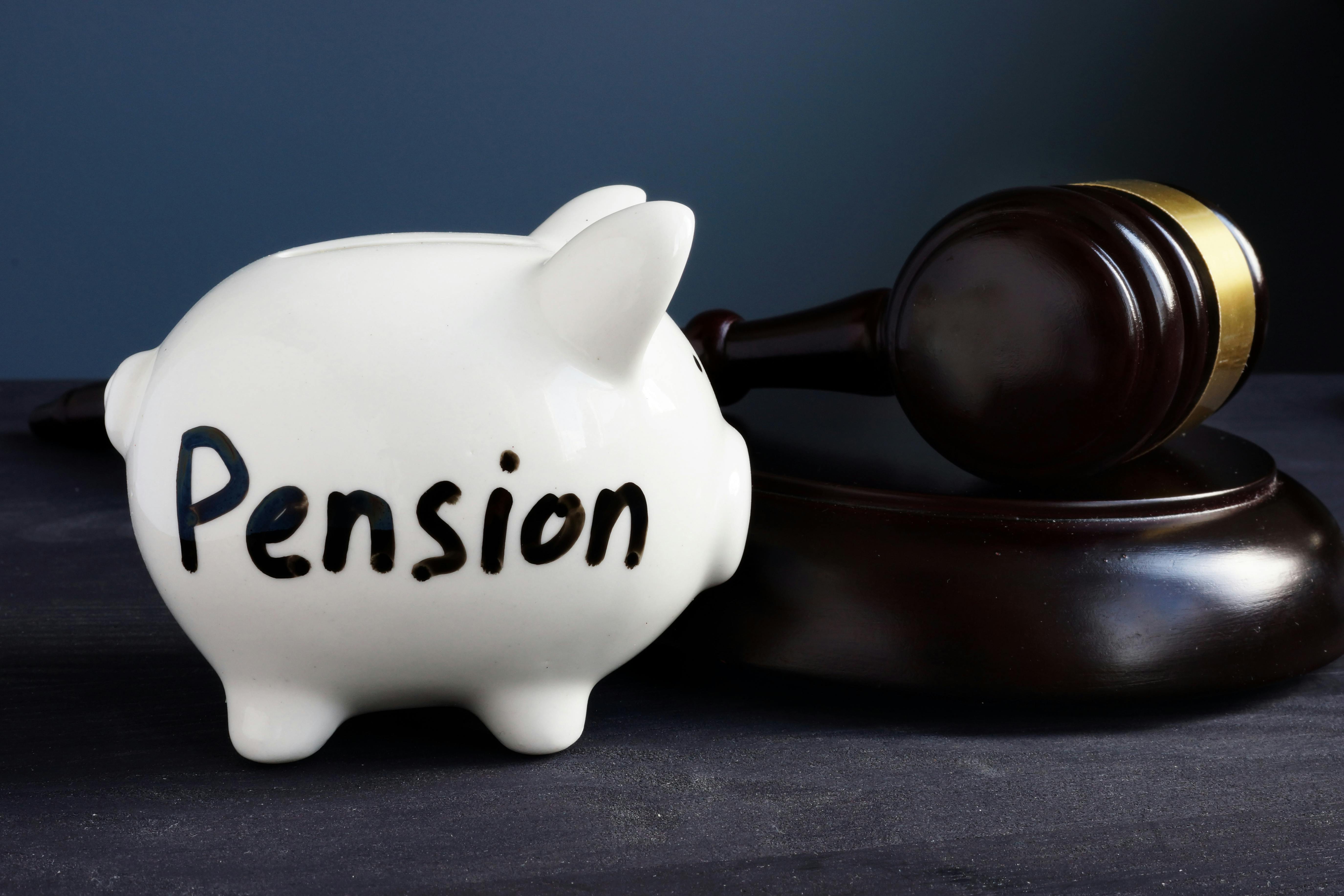 Gavel and piggy bank with sign pension. Legal and law concept.
