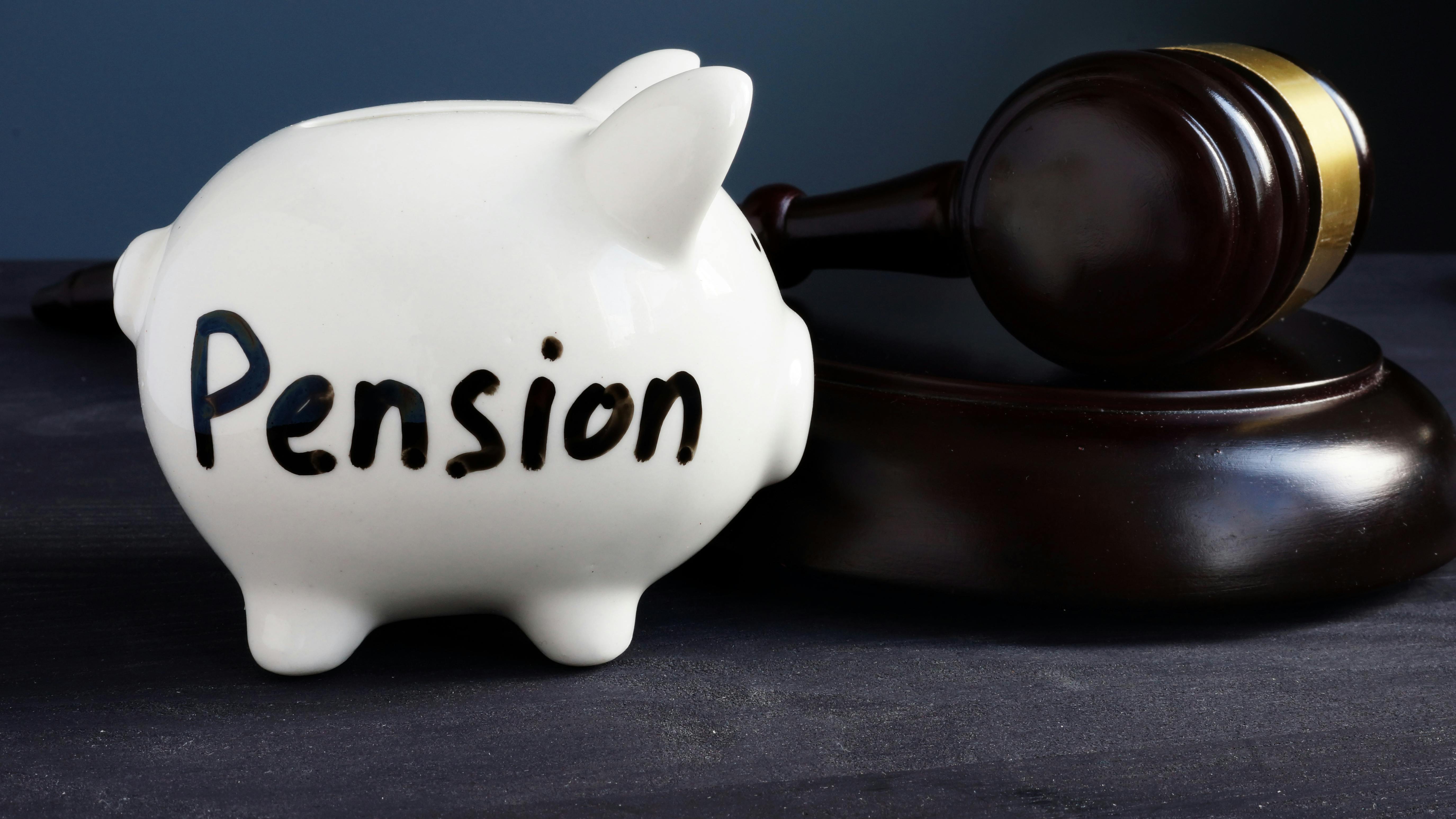 Gavel and piggy bank with sign pension. Legal and law concept.