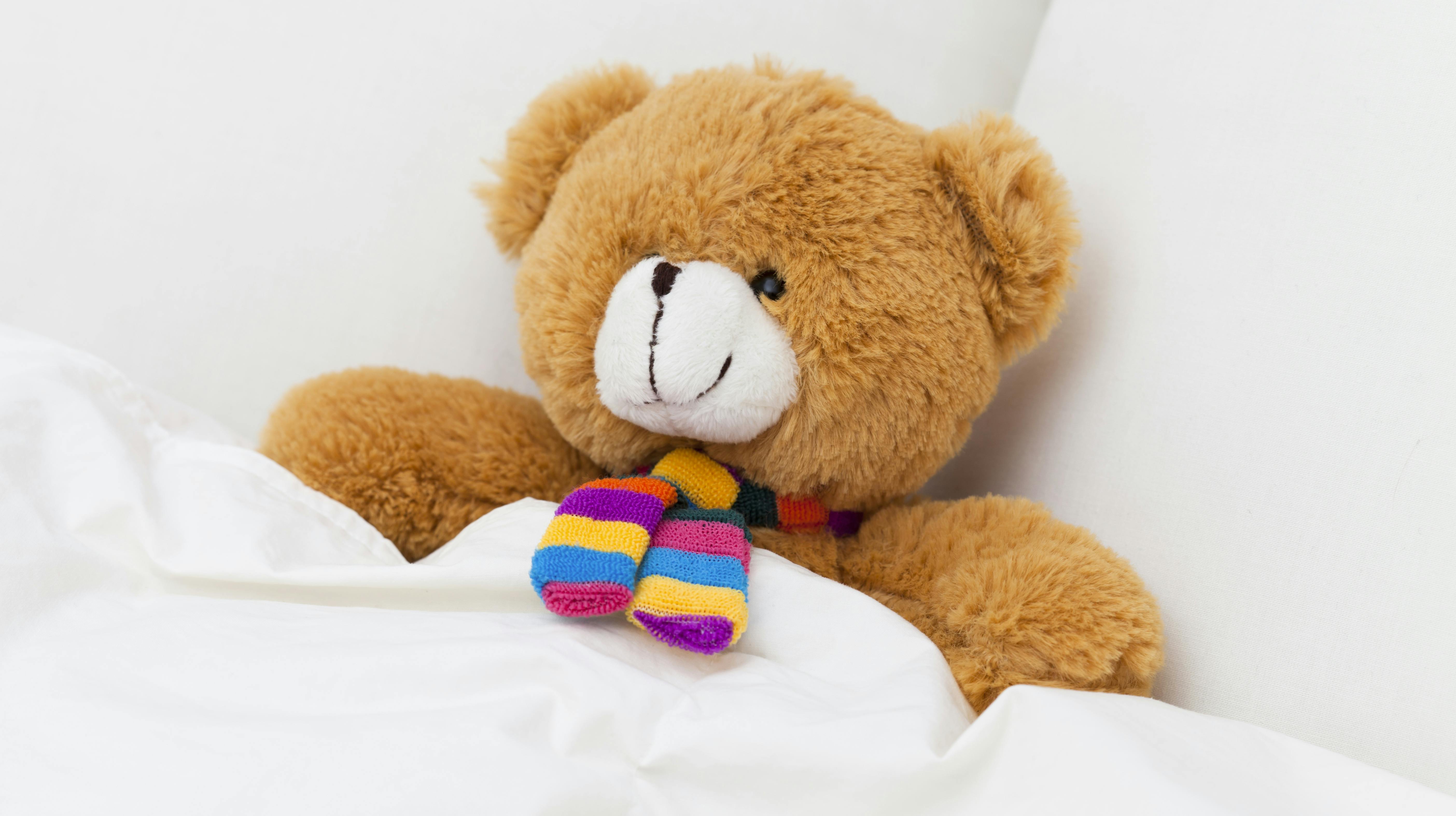 Teddy bear sleeping in a bed