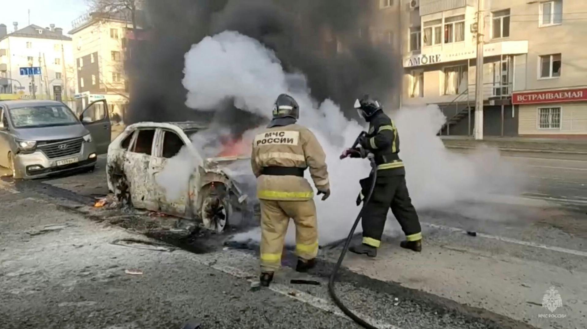 Brandmænd er i gang med at slukke en brændende bil i den russiske by Belgorod, der ifølge russiske myndigheder er ramt af et ukrainsk angreb lørdag.