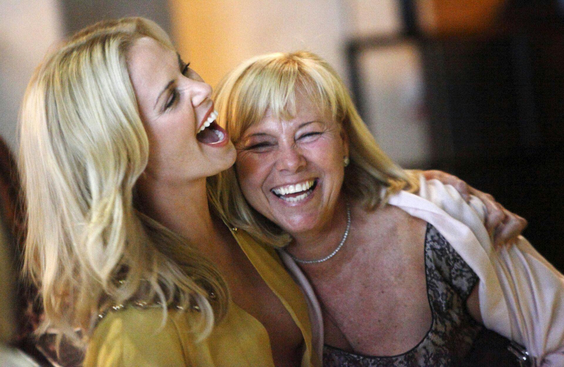 South African actress Charlize Theron (L) laughs with her mom Gerda as she arrives for the premiere party of the film "The Burning Plain" in Los Angeles, September 14, 2009. REUTERS/Danny Moloshok (UNITED STATES ENTERTAINMENT)