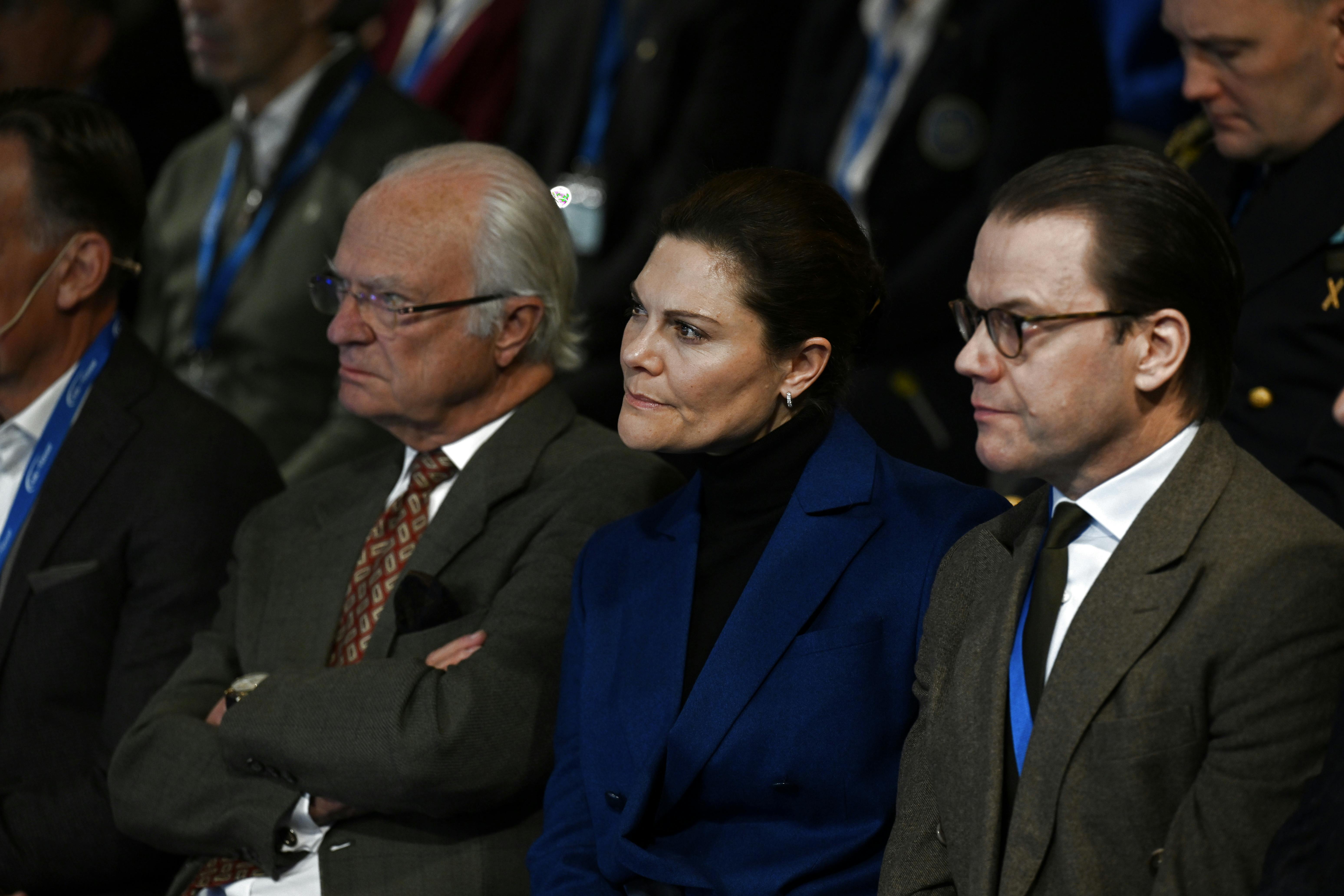 Her er kronprinsesse Victoria, 46, fanget under et mere årvågent øjeblik til Folk och Försvars Rikskonferens. Hun sidder mellem sin far kong Carl Gustaf, 77, og sin mand prins Daniel, 50. 
