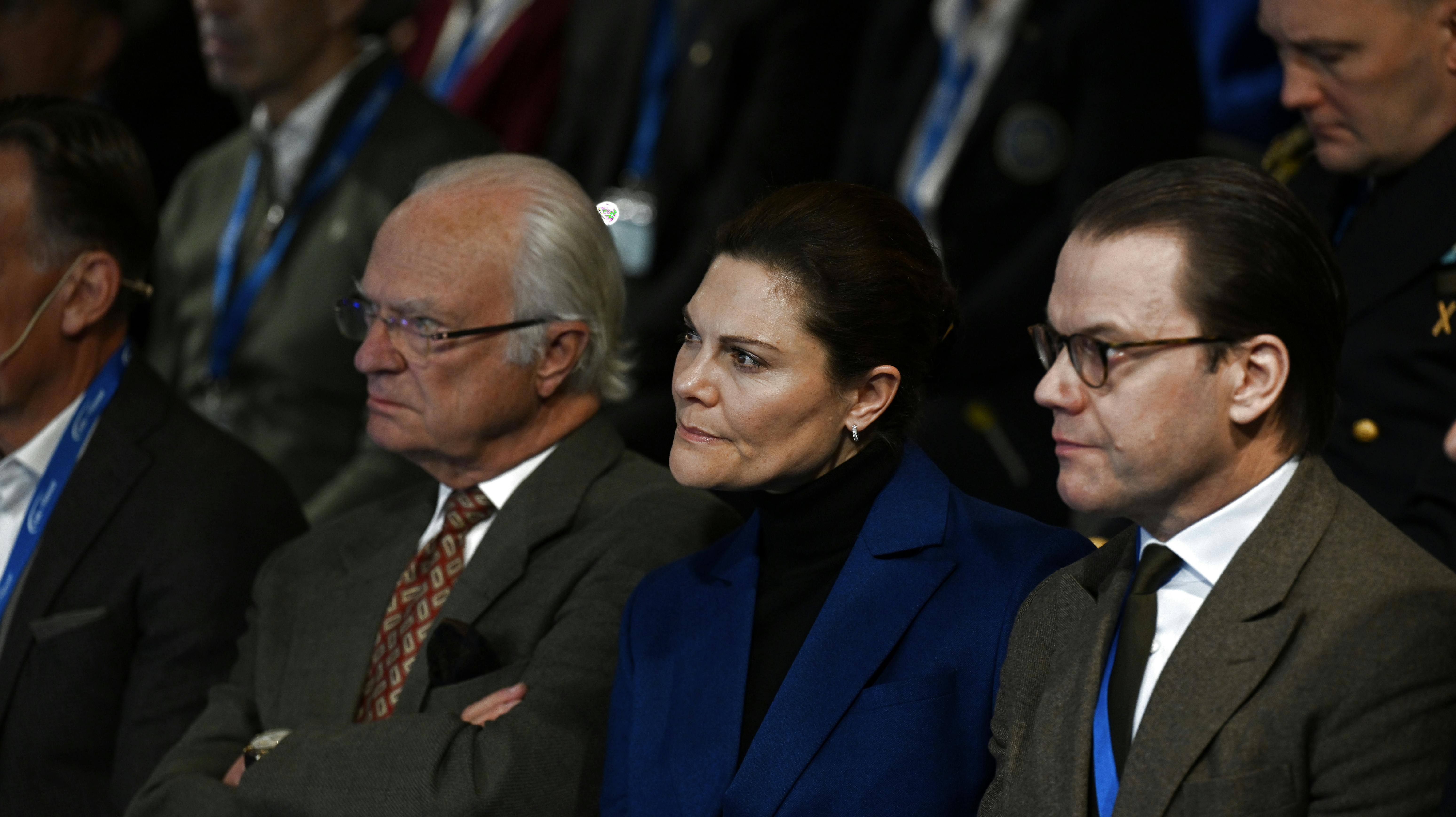 Her er kronprinsesse Victoria, 46, fanget under et mere årvågent øjeblik til Folk och Försvars Rikskonferens. Hun sidder mellem sin far kong Carl Gustaf, 77, og sin mand prins Daniel, 50.