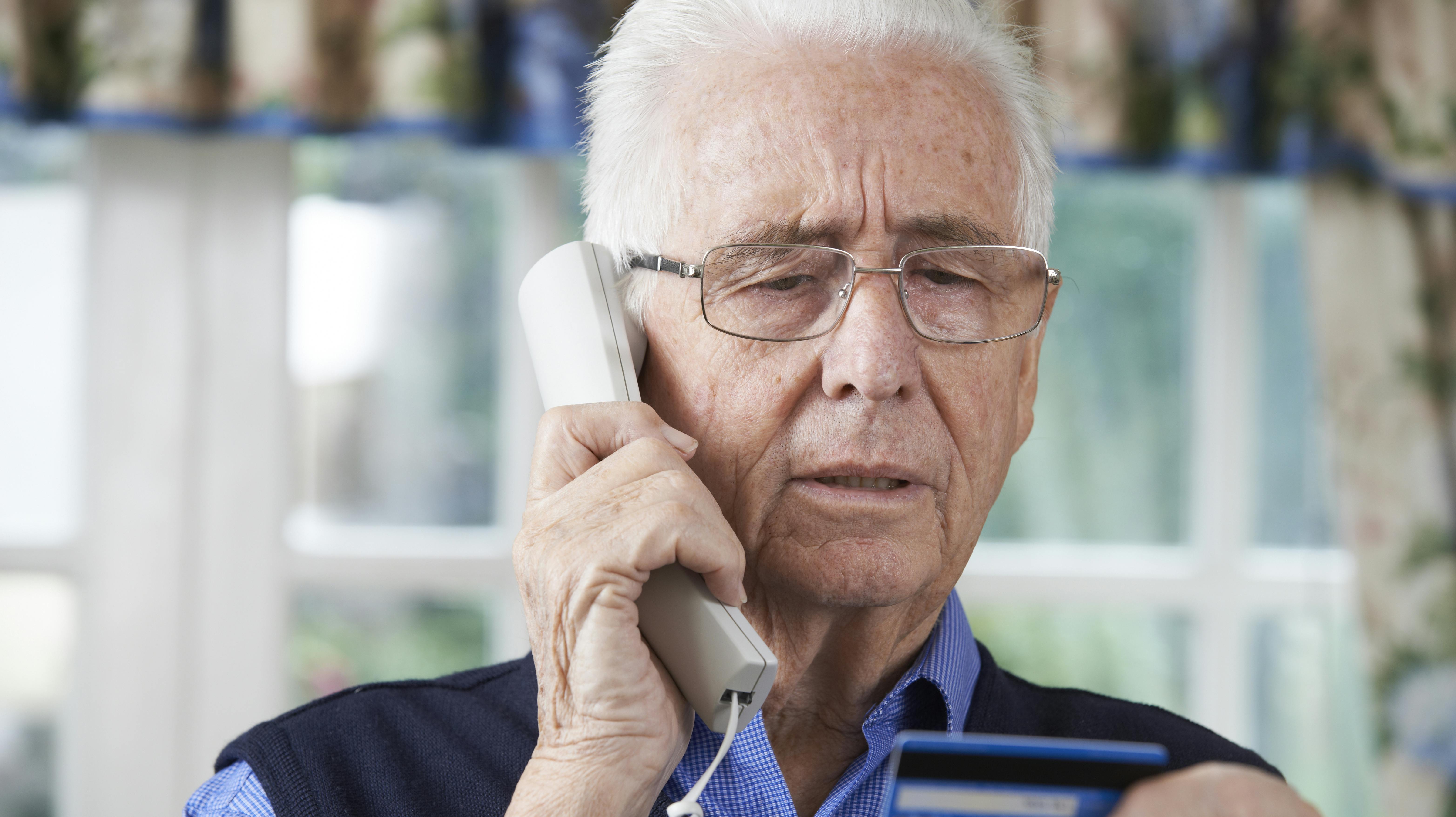 Senior Man Giving Credit Card Details On The Phone