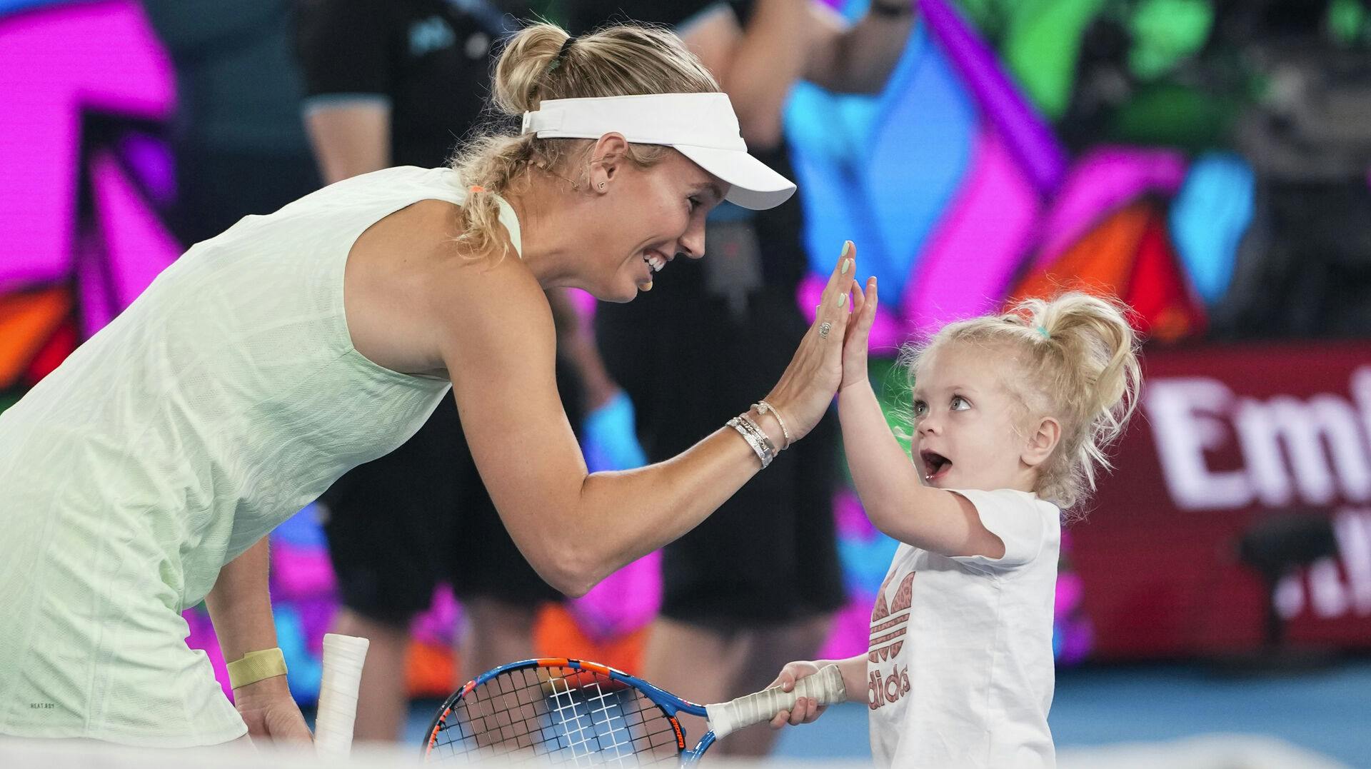 Denmark's Caroline Wozniacki reacts with her daughter Olivia during a charity on Rod Laver Arena ahead of the Australian Open tennis championships at Melbourne Park, Melbourne, Australia, Saturday, Jan. 13, 2024. (AP Photo/Alessandra Tarantino)