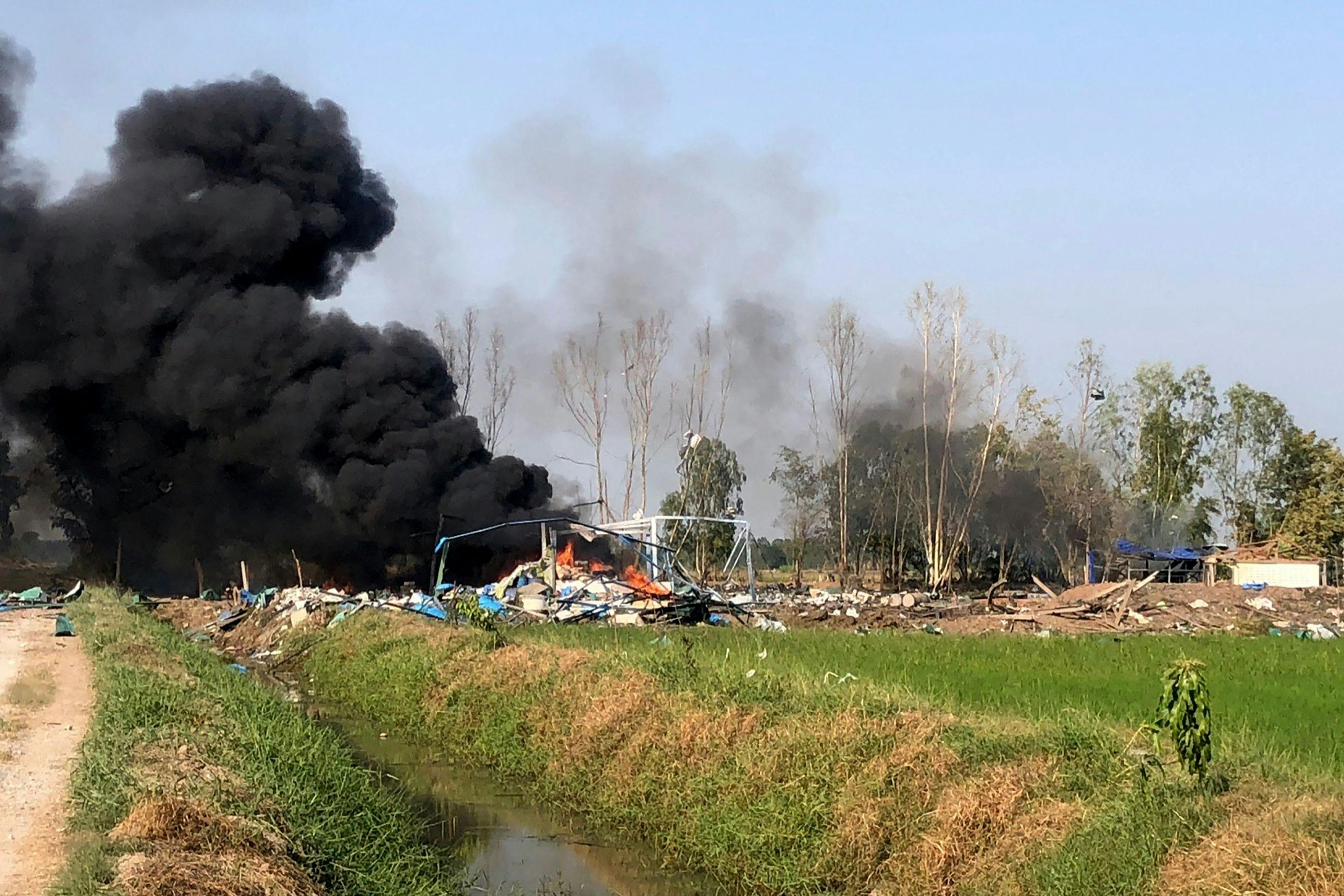 Røg stiger op fra området i Suphan Buri i det centrale Thailand, hvor en tragisk fyrværkeriulykke på en fabrik har krævet adskillige menneskeliv 