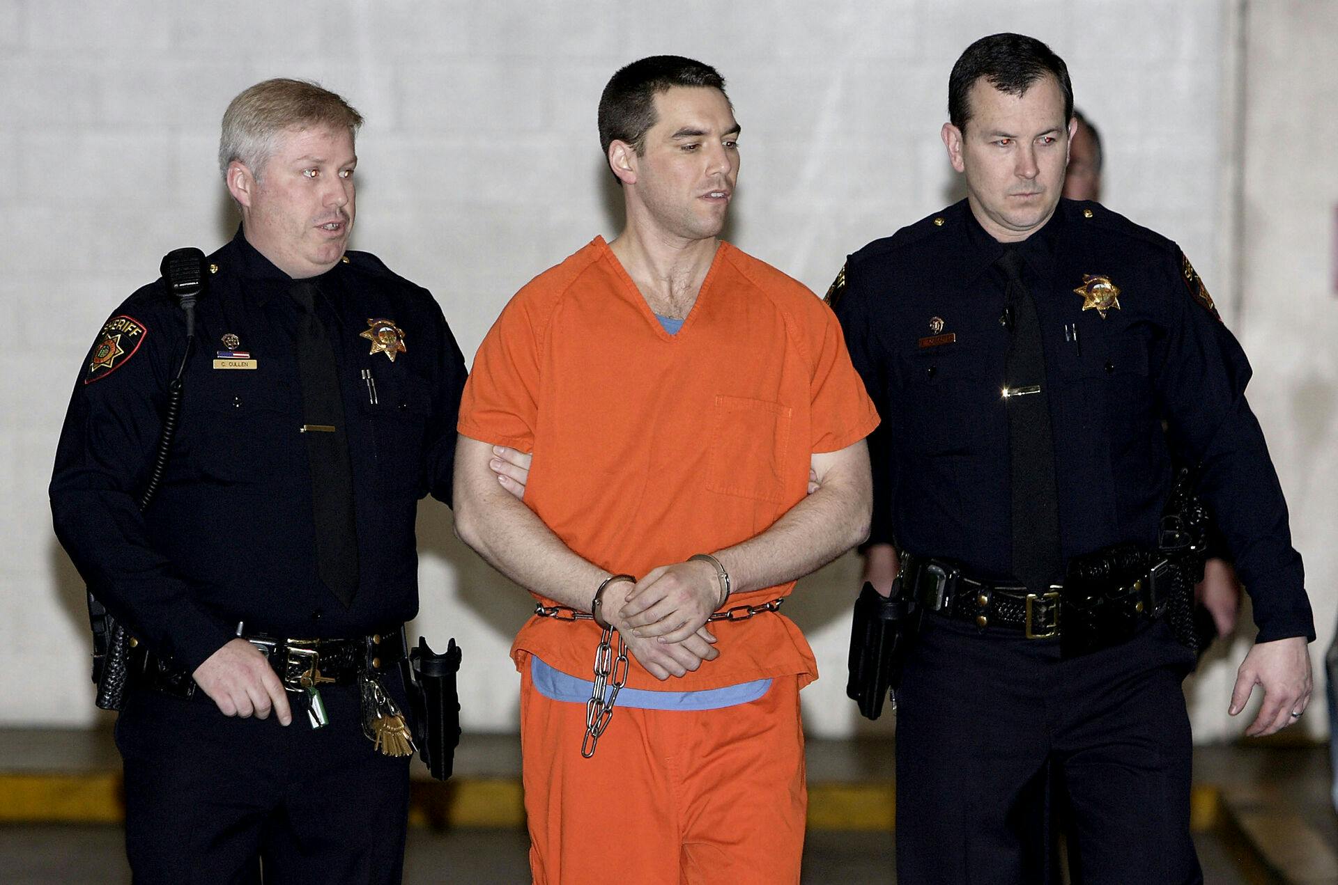 Convicted murderer Scott Peterson is escorted by two San Mateo County Sheriff deputies as he is walked from the jail to an awaiting van March 17, 2005 in Redwood City, California. Scott Peterson was transported to San Quentin Prison death row after he was formally sentenced to death for the murder or his wife Laci and their unborn son. AFP PHOTO/POOL/ Justin Sullivan