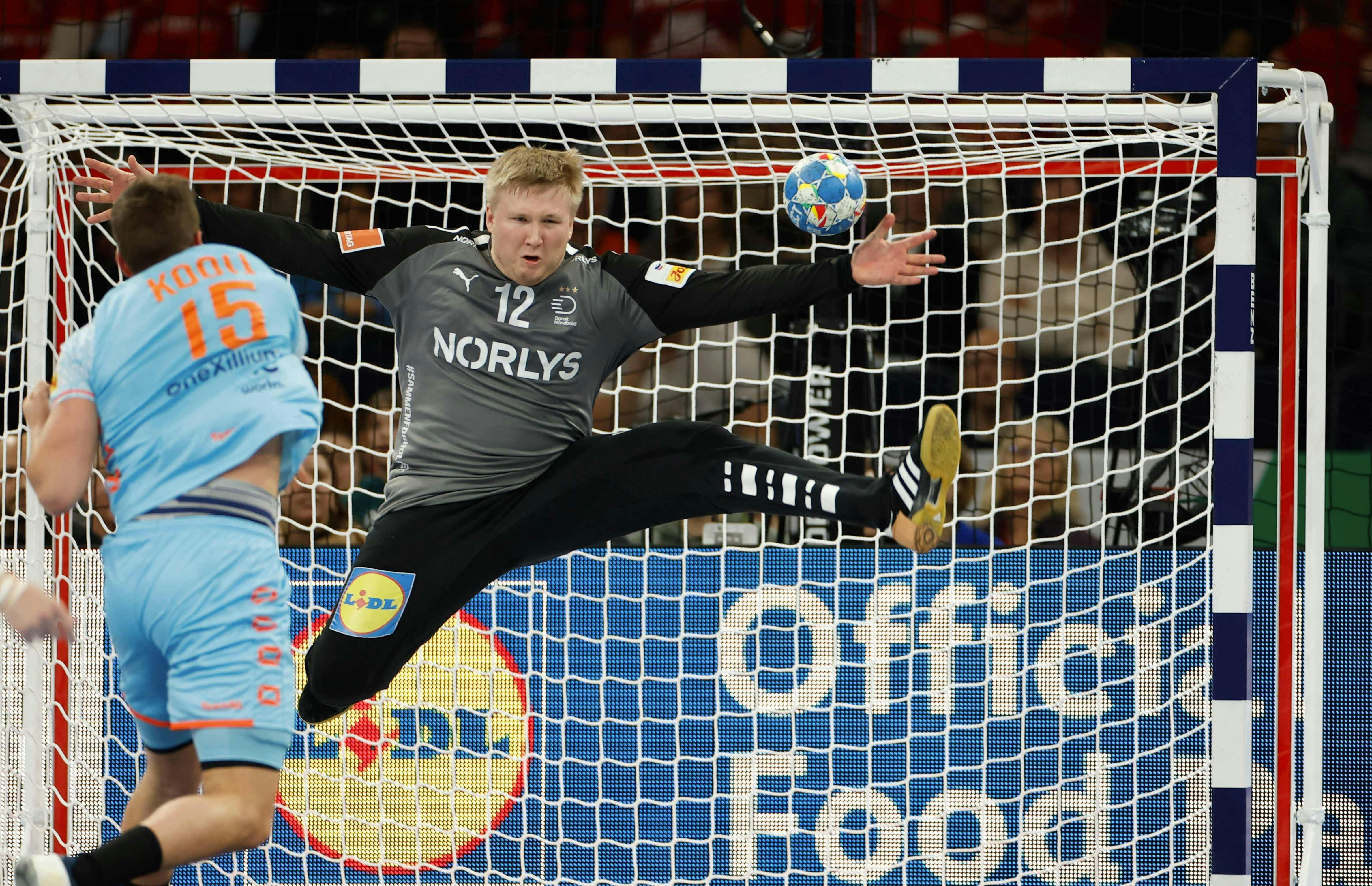 Denmark's goalkeeper #12 Emil Nielsen reaches for the ball during the Men's EURO 2024 EHF Handball European Championship main round match between Denmark and The Netherlands in Hamburg, northern Germany on January 17, 2024. (Photo by Odd ANDERSEN / AFP)