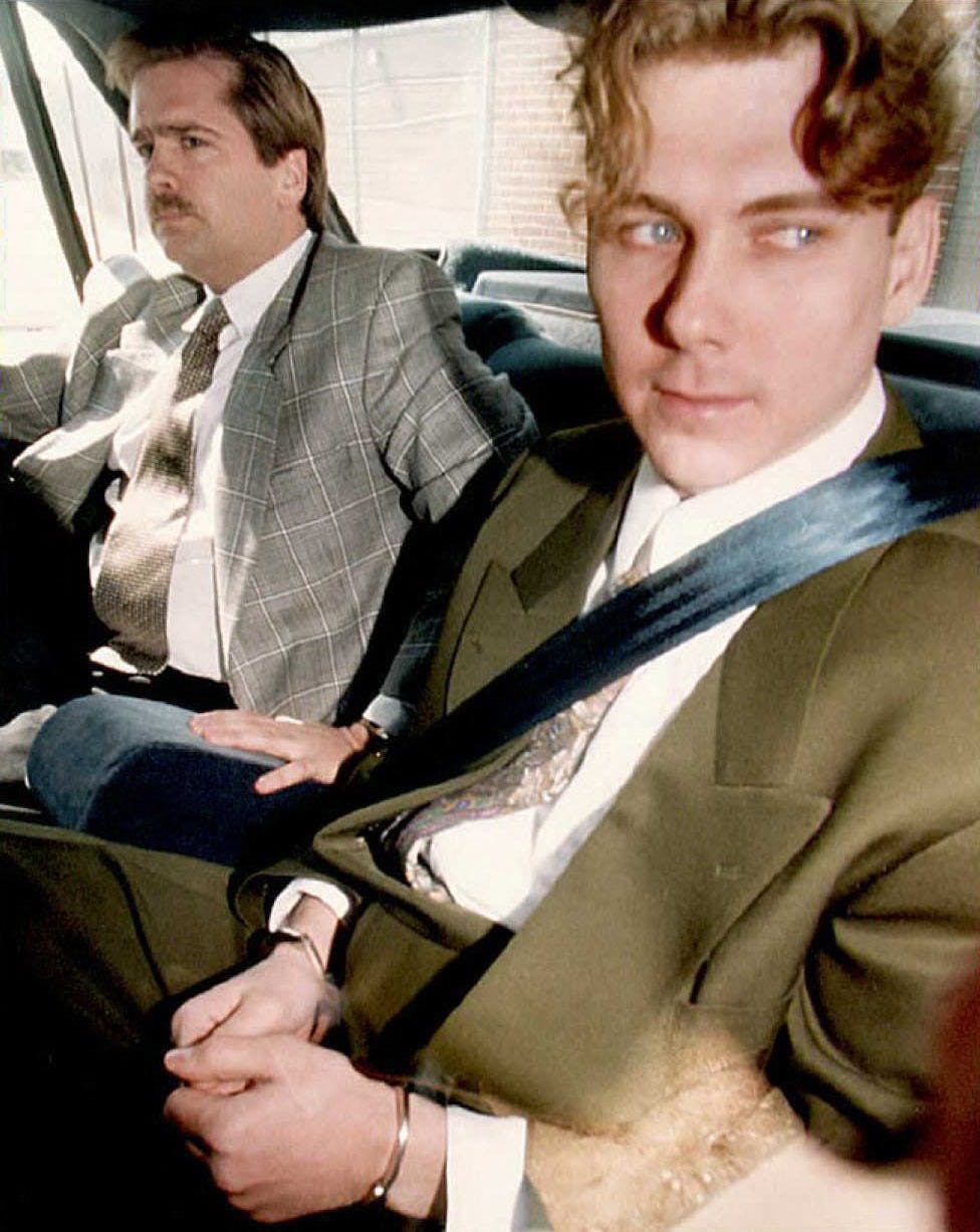 This summer 1994 file photo shows accused sex slayer Paul Bernardo (R) on his way to a pre-trial hearing with a member of the Toronto Police. Bernardo's trial begins 01 May with jury selection. Up to 1, 500 potentioal jurors have been summoned to appear.    AFP PHOTO. CARLO ALLEGRI / AFP FILES / AFP