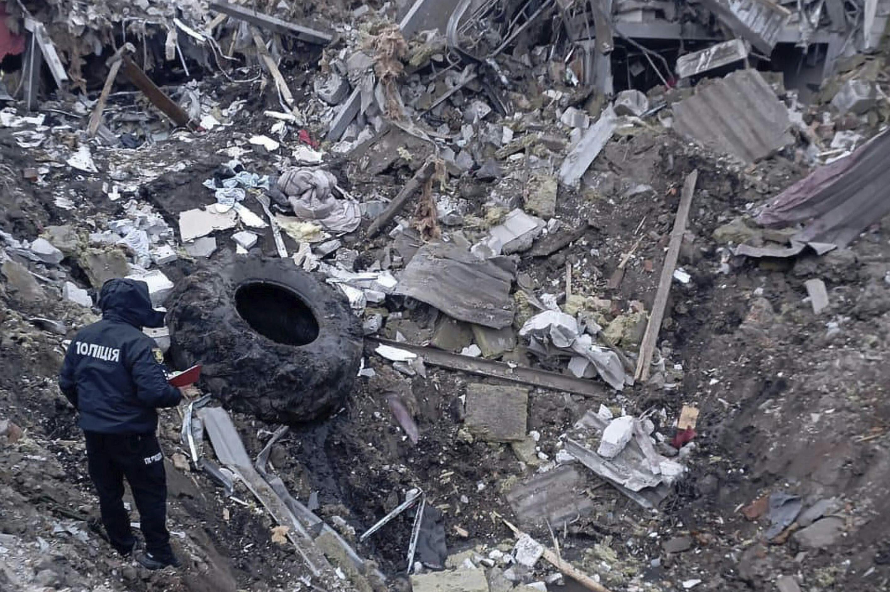 Nogle af ødelæggelserne besigtiges efter tirsdagens angreb i byen Zolotsjiv.